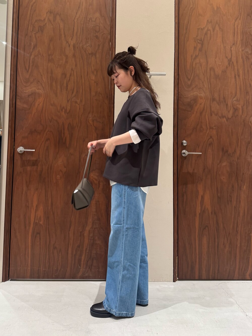 ホワイト系のシャツ/ブラウス、ブルー系のデニムパンツ、ブラック系のブーツを着用したレディースの冬コーディネートの2枚目の写真