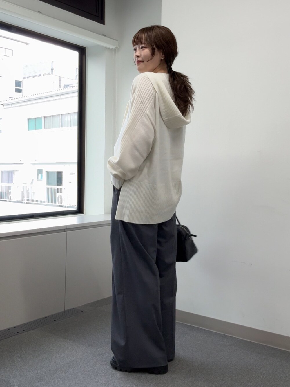 ホワイト系のニット/セーター、グレー系のその他パンツ、ブラック系のブーツを着用したレディースの秋コーディネートの2枚目の写真