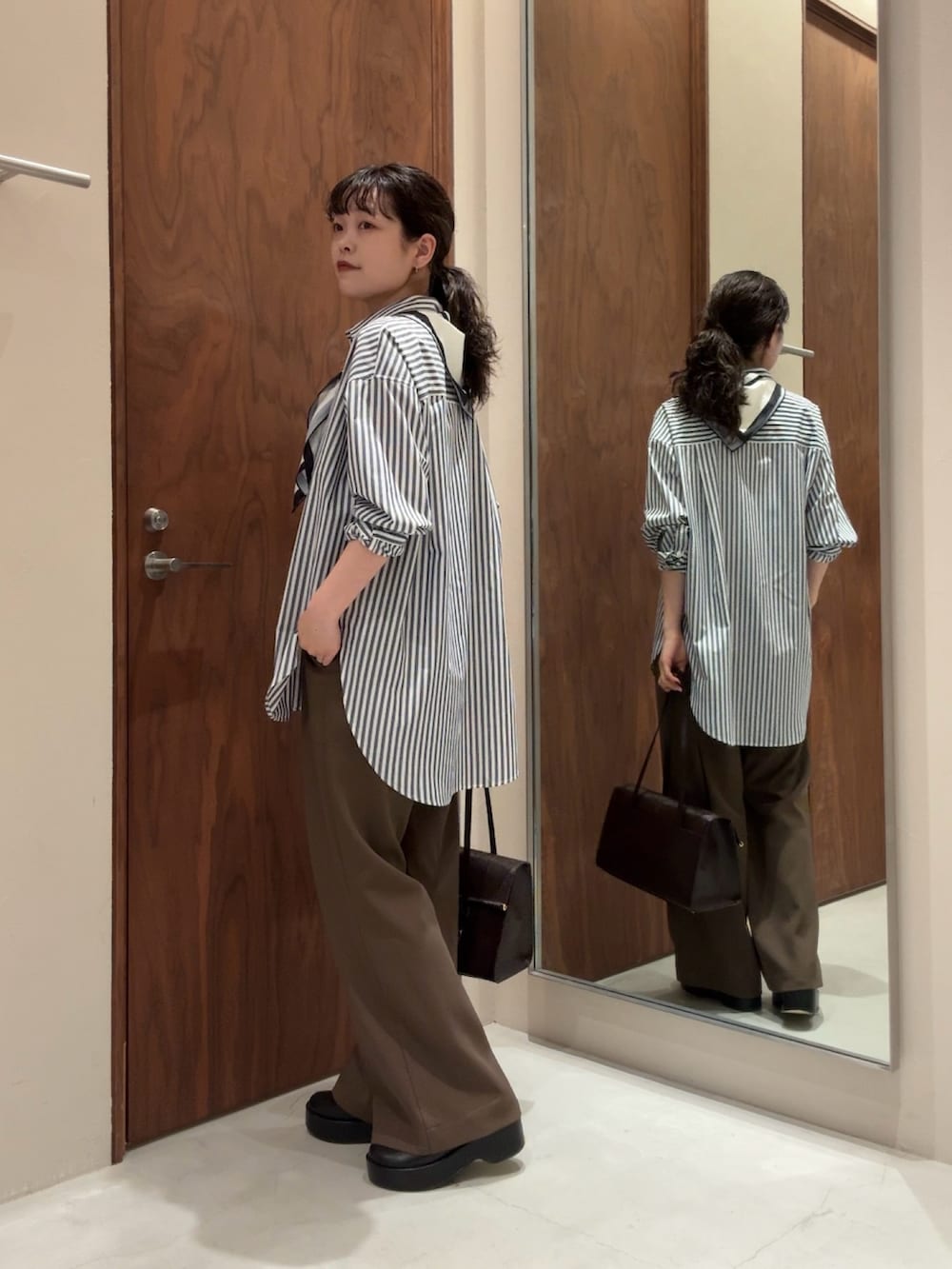 ブルー系のシャツ/ブラウス、ブラック系のその他パンツ、ブラック系のブーツを着用したレディースの冬コーディネートの4枚目の写真