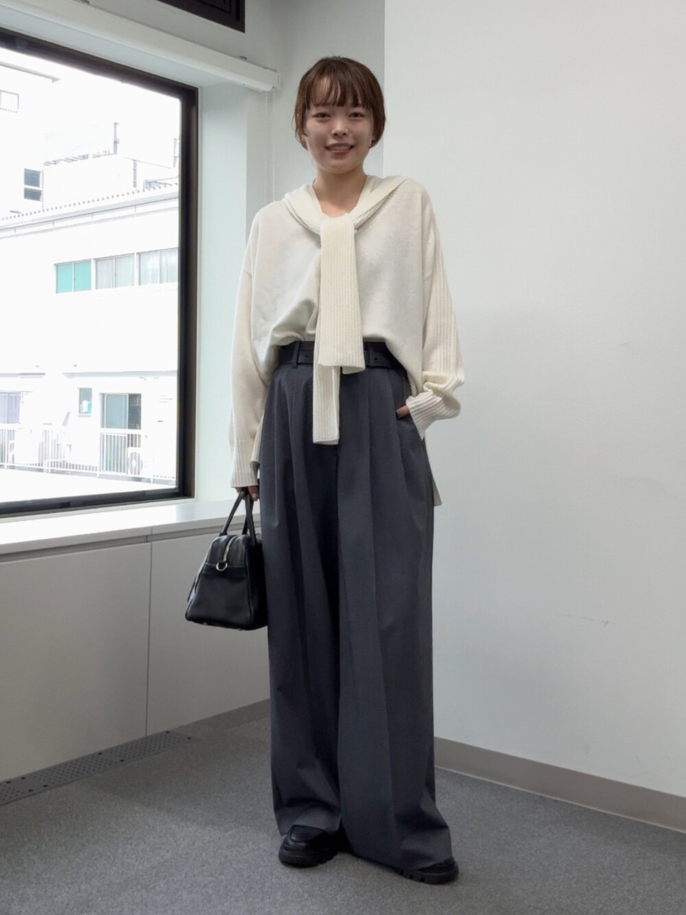 ホワイト系のニット/セーター、グレー系のその他パンツ、ブラック系のブーツを着用したレディースの秋コーディネートの4枚目の写真