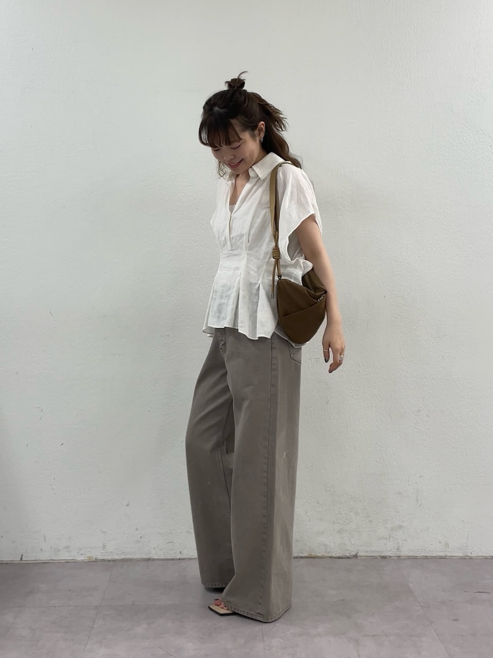 ホワイト系のシャツ/ブラウス、ブラウン系のデニムパンツ、イエロー系のショルダーバッグを着用したレディースの春コーディネートの5枚目の写真