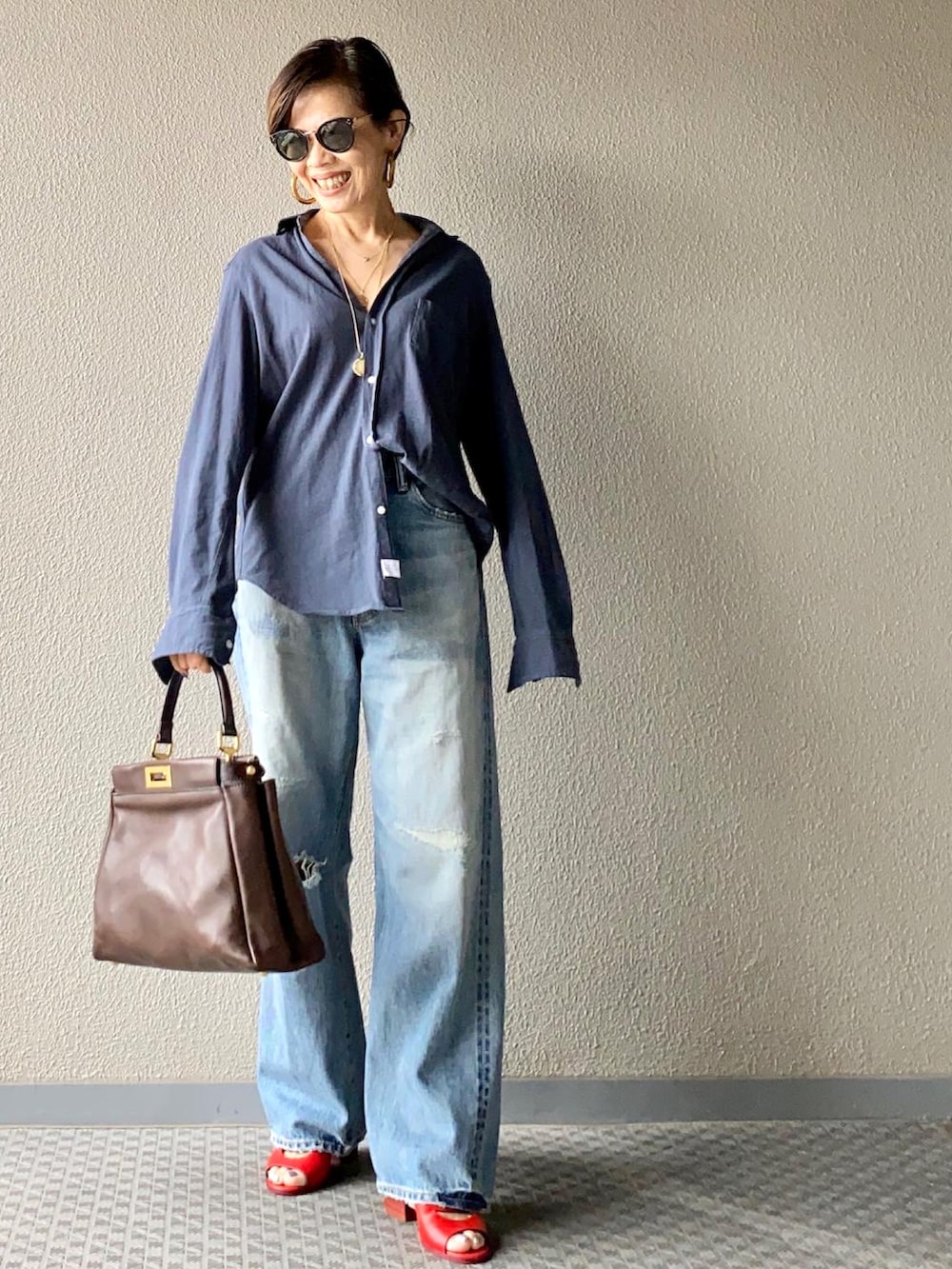 ブルー系のデニムパンツ、ブルー系のシャツ/ブラウス、ブラウン系のバッグを着用したレディースの夏コーディネートの3枚目の写真