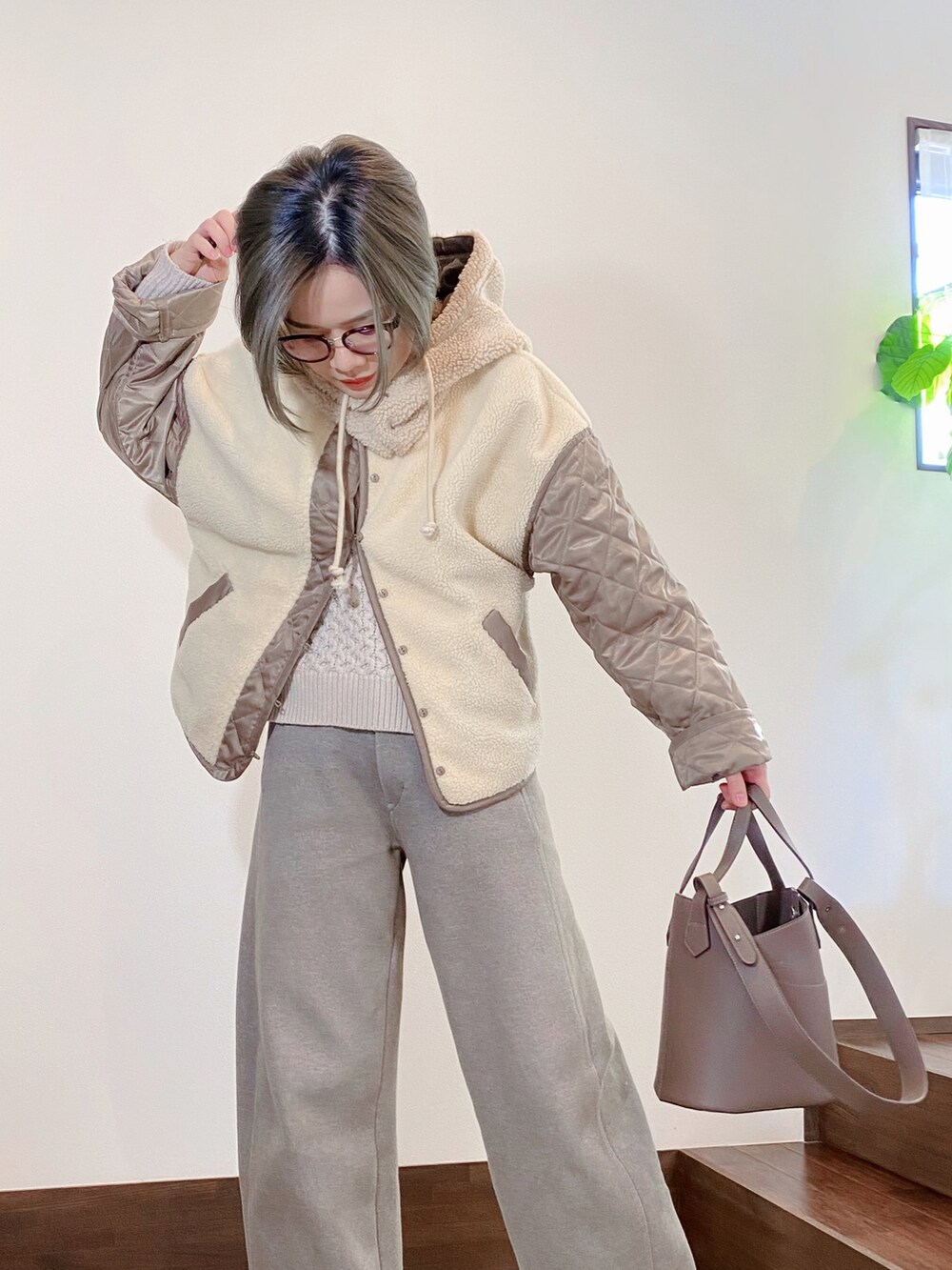 グリーン系のブルゾン、ベージュ系のショルダーバッグ、ベージュ系のその他パンツを着用したレディースの冬コーディネートの2枚目の写真