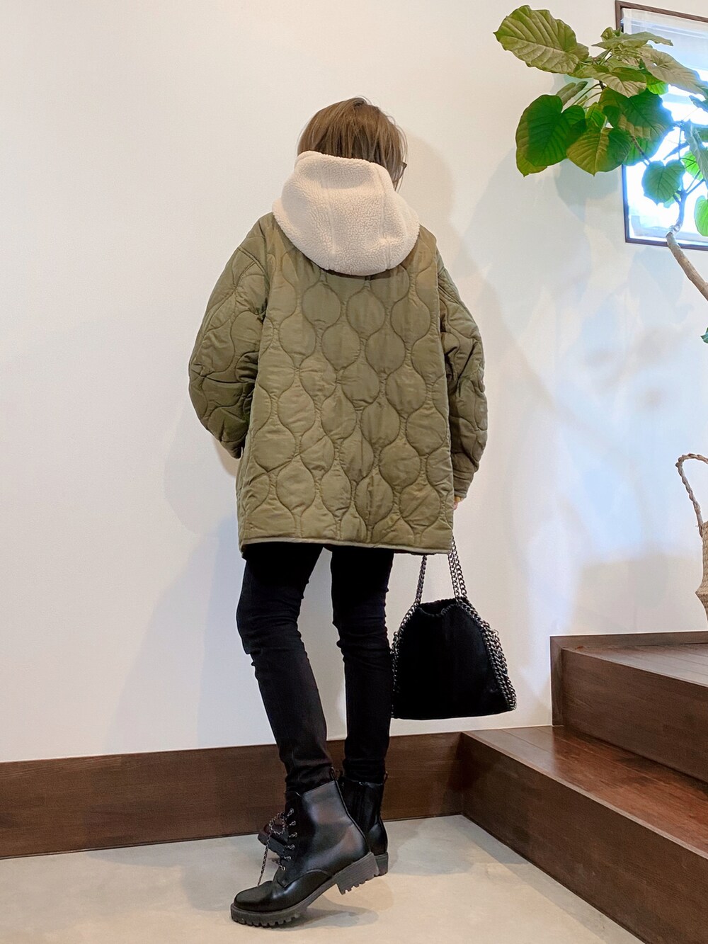 グリーン系のダウンジャケット/コート、イエロー系のニット/セーター、ベージュ系のマフラーを着用したレディースの秋コーディネートの4枚目の写真