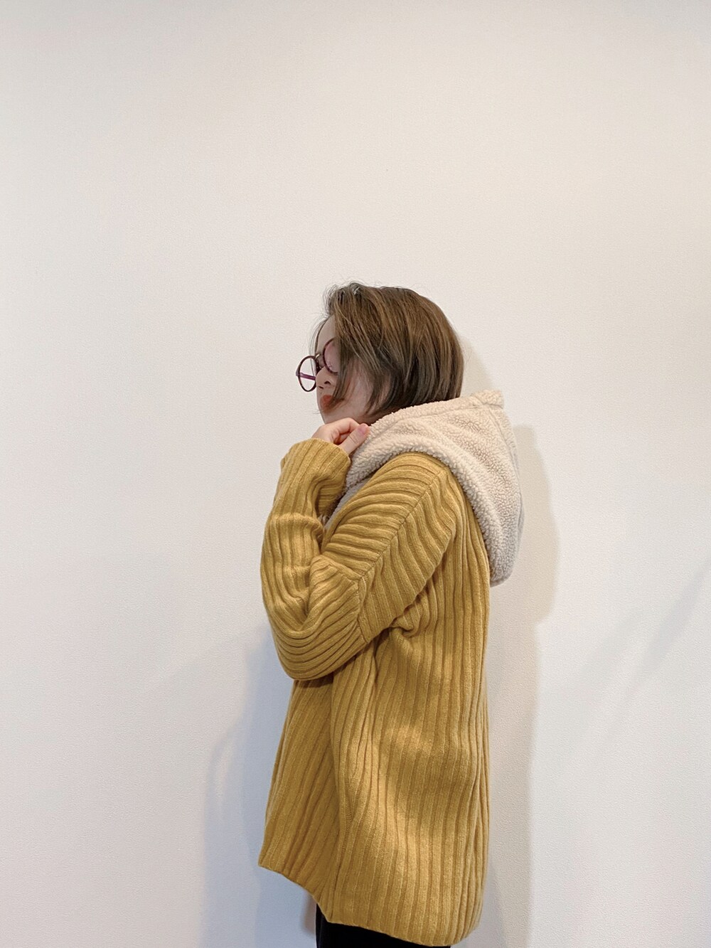 グリーン系のダウンジャケット/コート、イエロー系のニット/セーター、ベージュ系のマフラーを着用したレディースの秋コーディネートの3枚目の写真