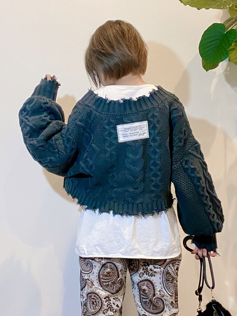 ブラウン系のその他パンツ、ブラック系のショルダーバッグ、グリーン系のニット/セーターを着用したレディースの秋コーディネートの2枚目の写真