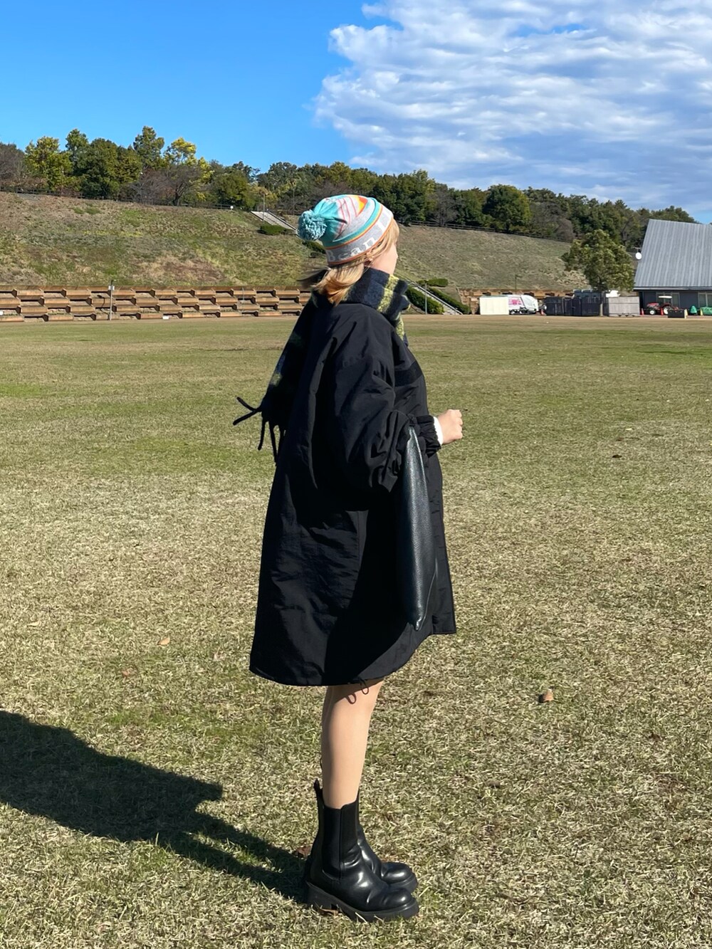 ブラック系のブーツ、ブルー系のマフラー、ブルー系のニットキャップ/ビーニーを着用したレディースの秋コーディネートの2枚目の写真