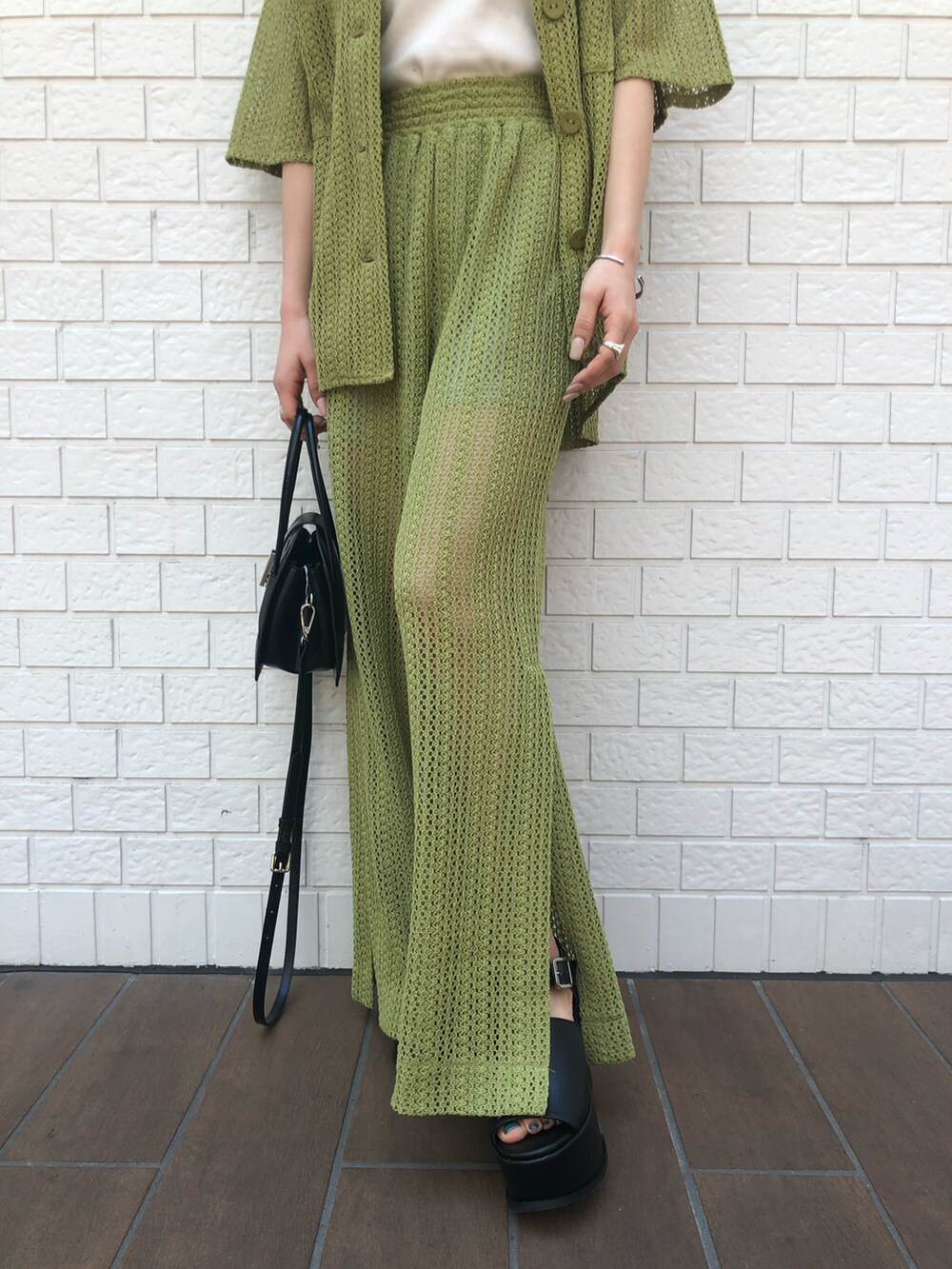 グリーン系のシャツ/ブラウス、グリーン系のスウェットパンツ、ブラック系のハンドバッグを着用したレディースの夏コーディネートの4枚目の写真