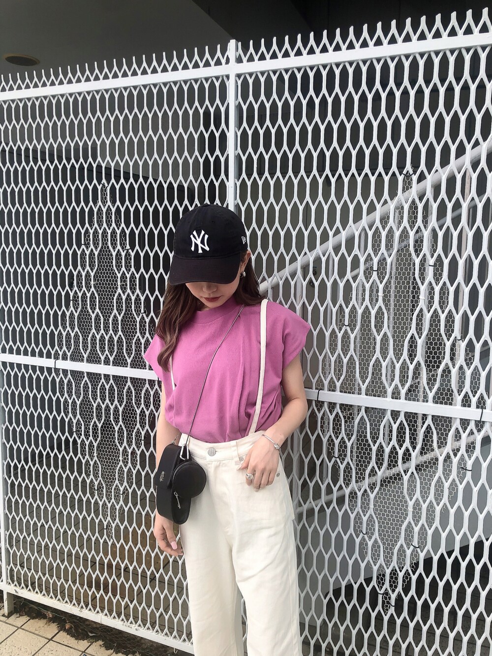 ホワイト系のデニムパンツ、ピンク系のタンクトップ、ブラック系のサンダルを着用したレディースの夏コーディネートの3枚目の写真