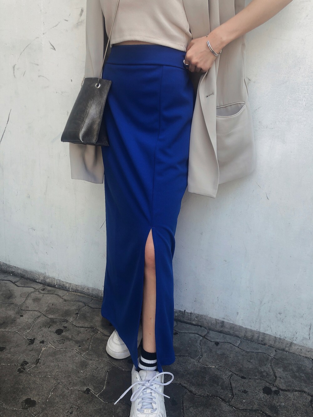 ブルー系のスカート、ホワイト系のキャミソール、ベージュ系のベストを着用したレディースの夏コーディネートの5枚目の写真