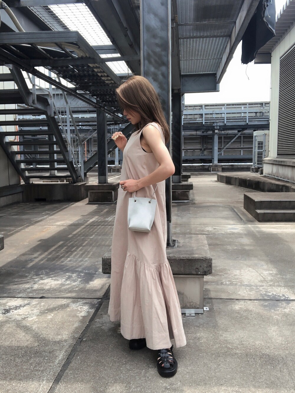 ブラック系のサンダル、ホワイト系のショルダーバッグ、ベージュ系のワンピースを着用したレディースの夏コーディネートの2枚目の写真