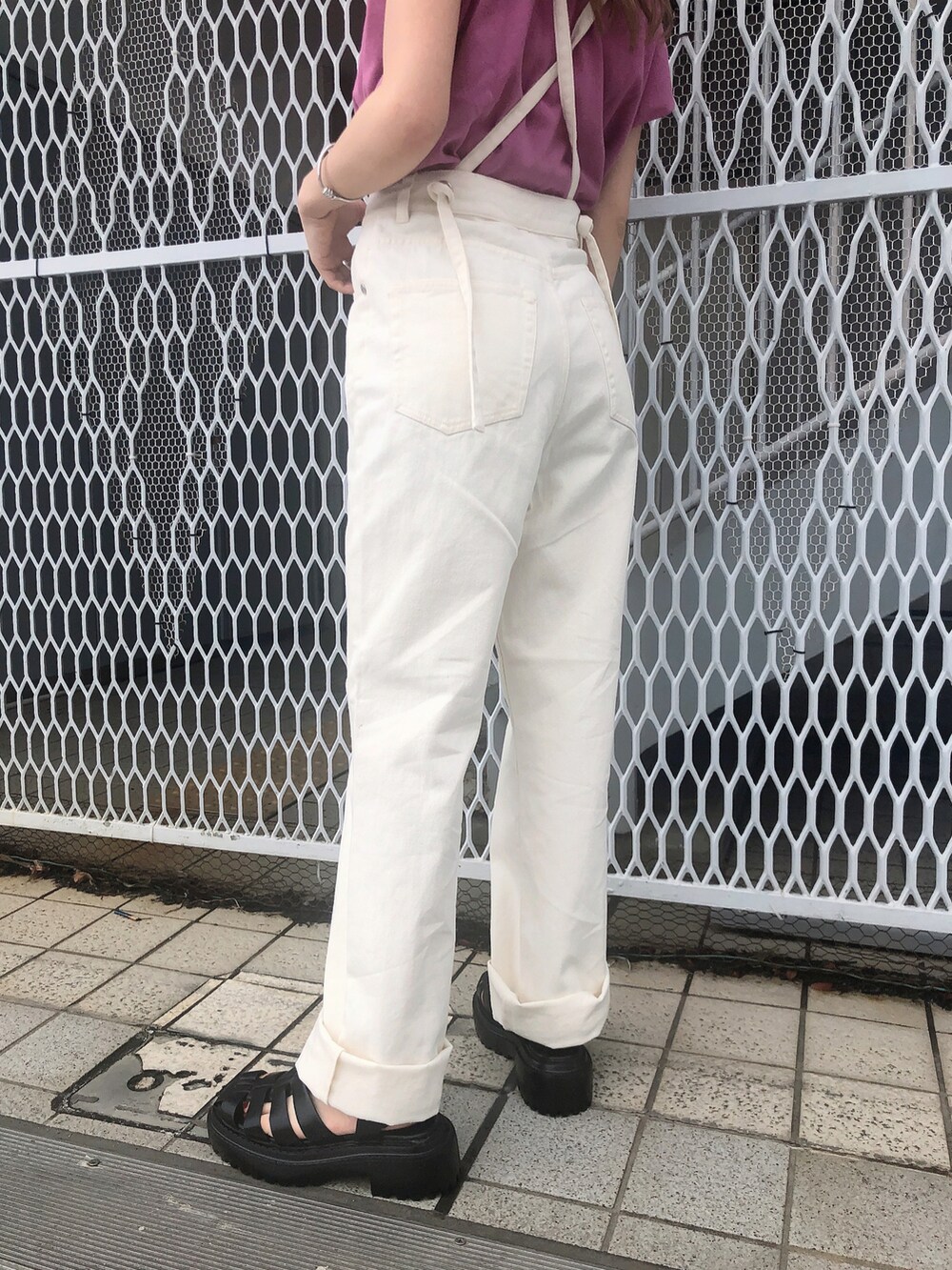 ホワイト系のデニムパンツ、ピンク系のタンクトップ、ブラック系のサンダルを着用したレディースの夏コーディネートの4枚目の写真