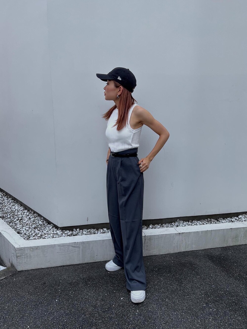 グレー系のスラックス、ホワイト系のタンクトップ、ホワイト系のスニーカーを着用したレディースの夏コーディネートの2枚目の写真