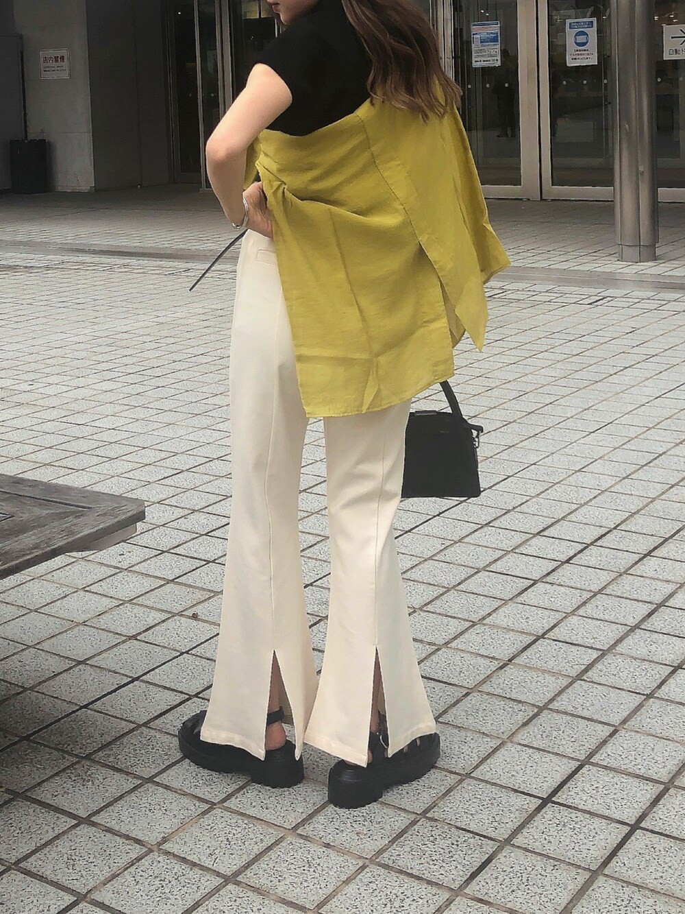 ブラック系のTシャツ/カットソー、ホワイト系のスラックス、イエロー系のシャツ/ブラウスを着用したレディースの夏コーディネートの3枚目の写真