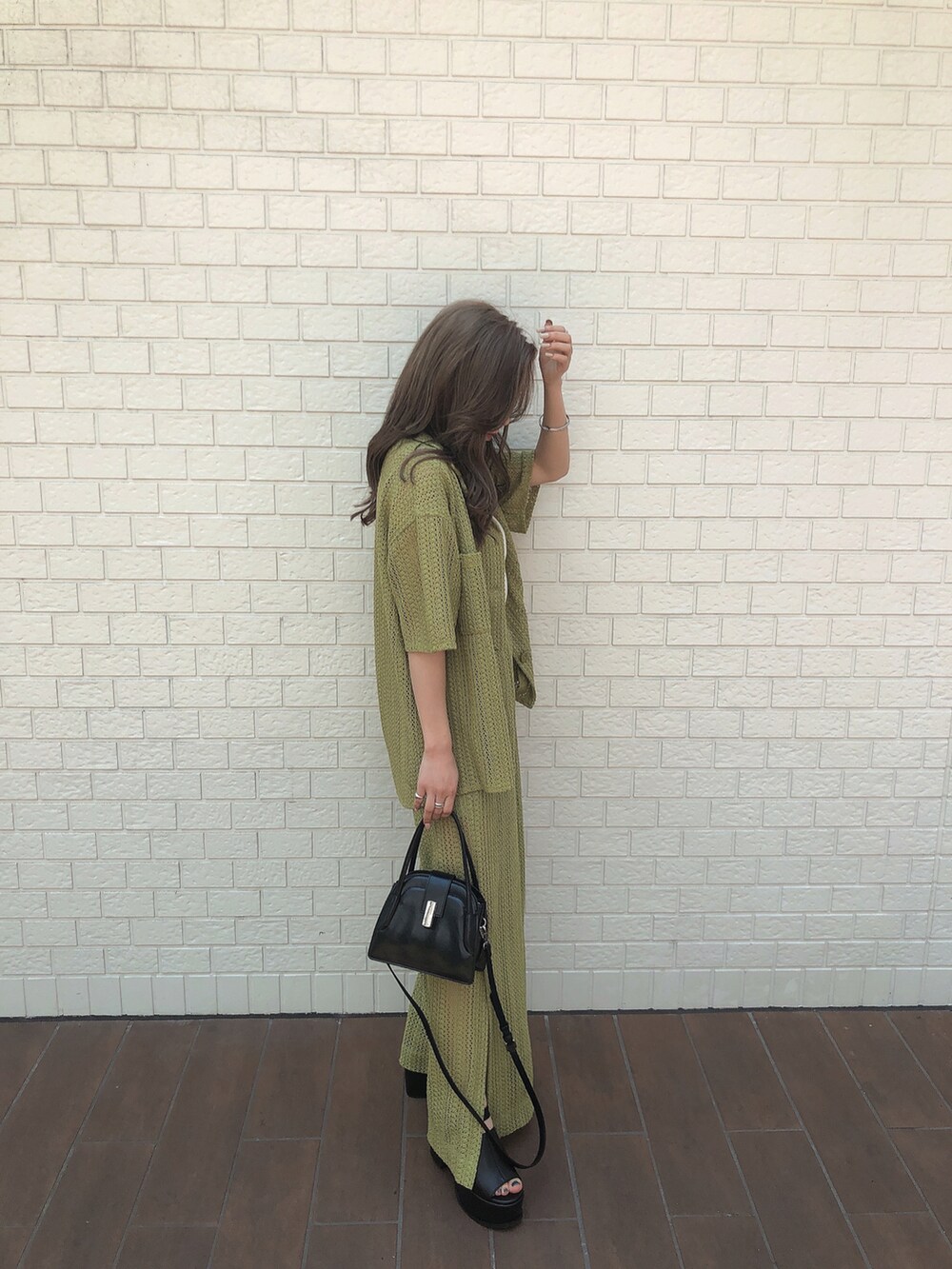 グリーン系のシャツ/ブラウス、グリーン系のスウェットパンツ、ブラック系のハンドバッグを着用したレディースの夏コーディネートの2枚目の写真