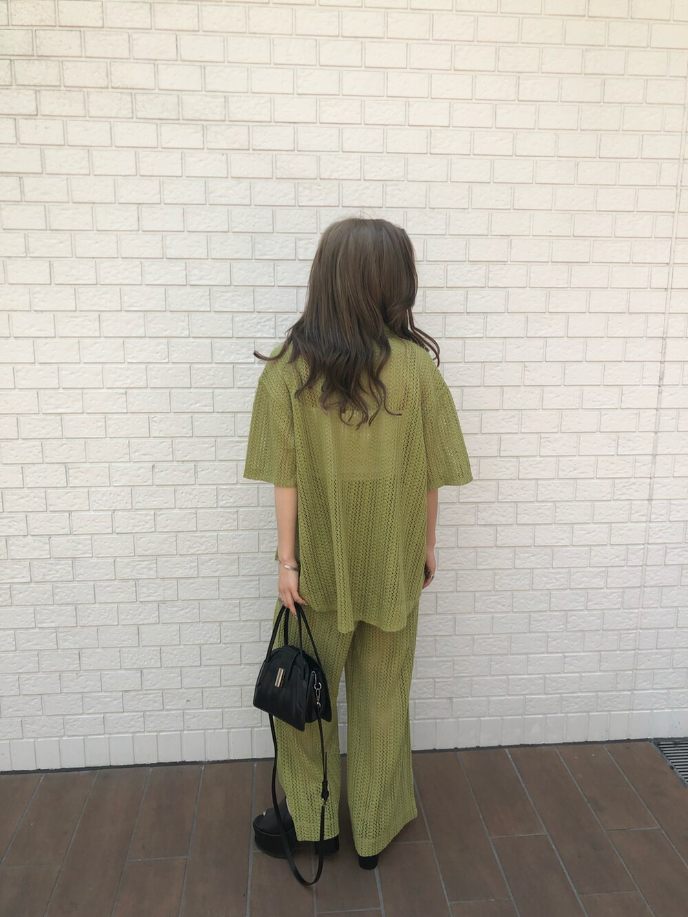 グリーン系のシャツ/ブラウス、グリーン系のスウェットパンツ、ブラック系のハンドバッグを着用したレディースの夏コーディネートの3枚目の写真