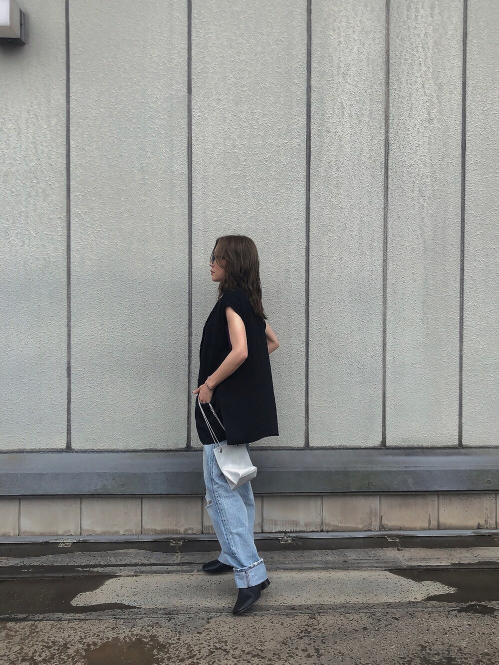 パープル系のタンクトップ、ブルー系のデニムパンツ、ブラック系のサンダルを着用したレディースの夏コーディネートの2枚目の写真