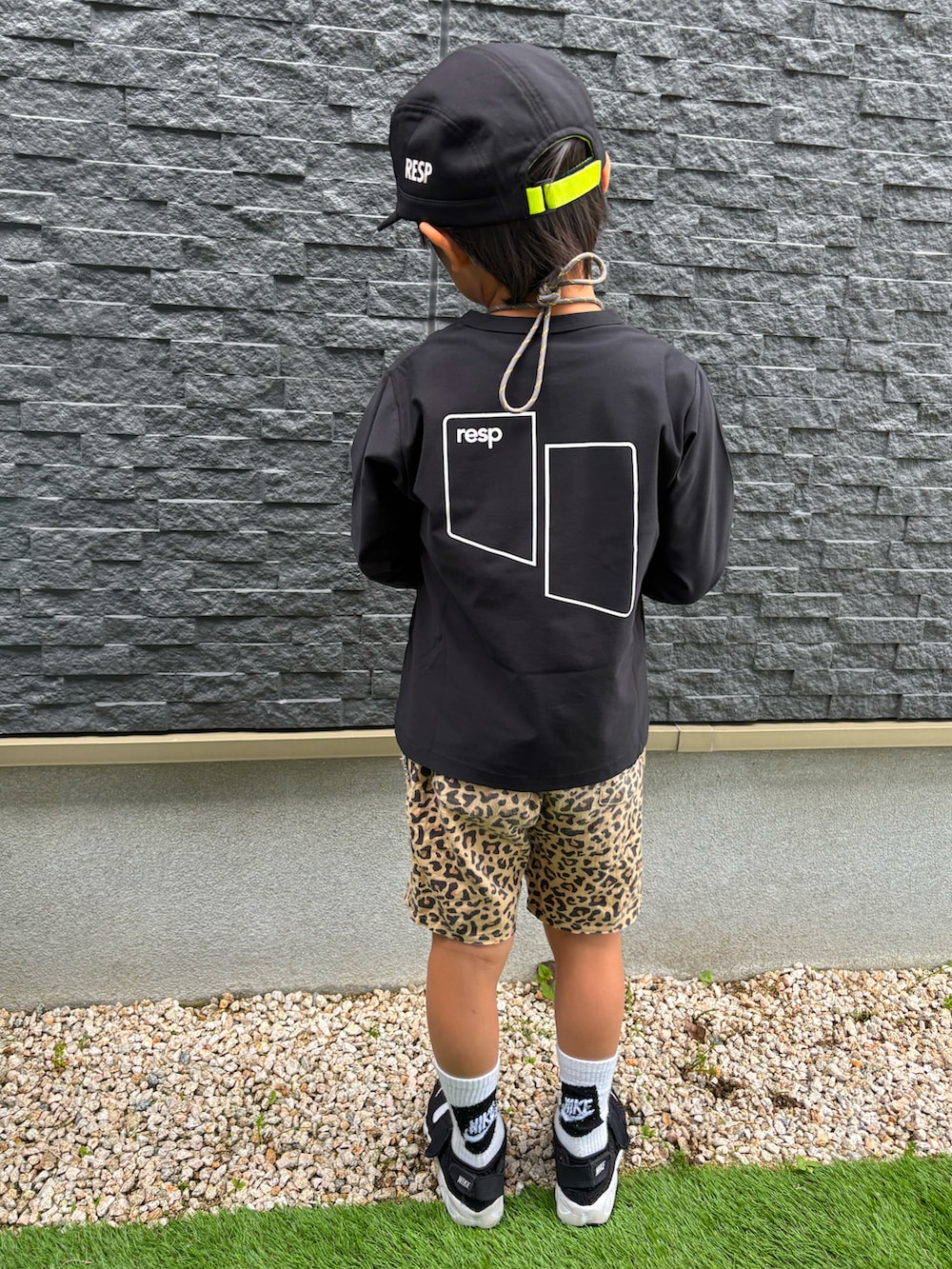 ブラック系のTシャツ/カットソー、ブラック系のスニーカー、ブラック系のキャップを着用したキッズの春コーディネートの2枚目の写真