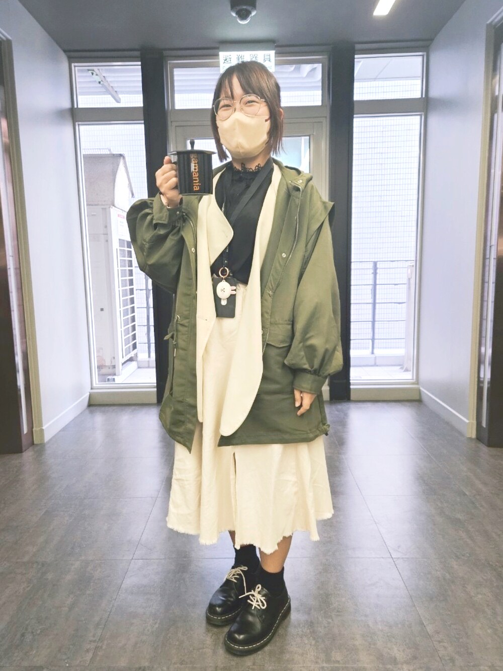 ホワイト系のジャケット/アウター、グリーン系のマウンテンパーカー、ブラック系のドレスシューズを着用したレディースの春コーディネートの4枚目の写真