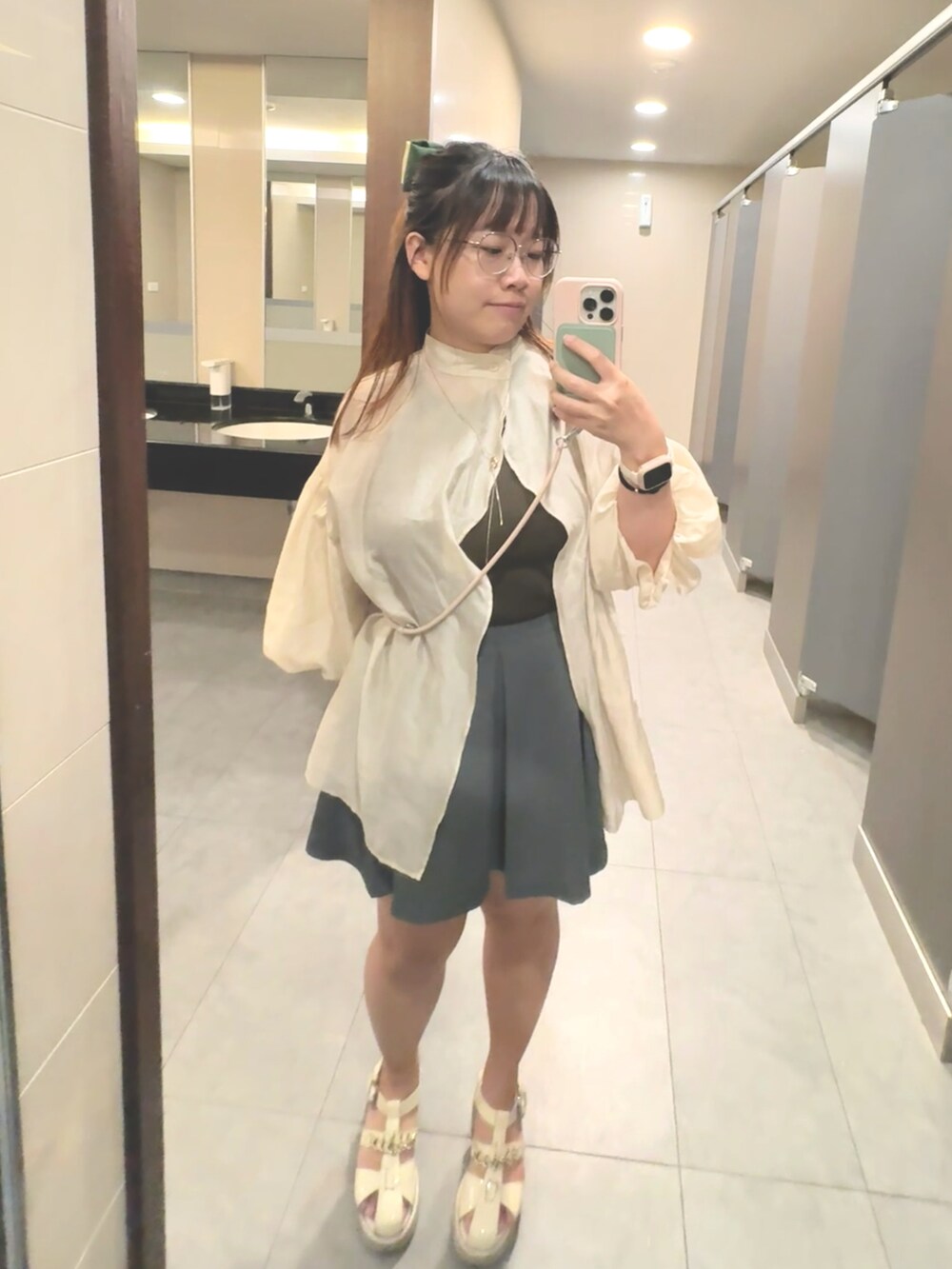 ベージュ系のシャツ/ブラウス、グリーン系のタンクトップ、グレー系のスカートを着用したレディースの秋コーディネートの2枚目の写真