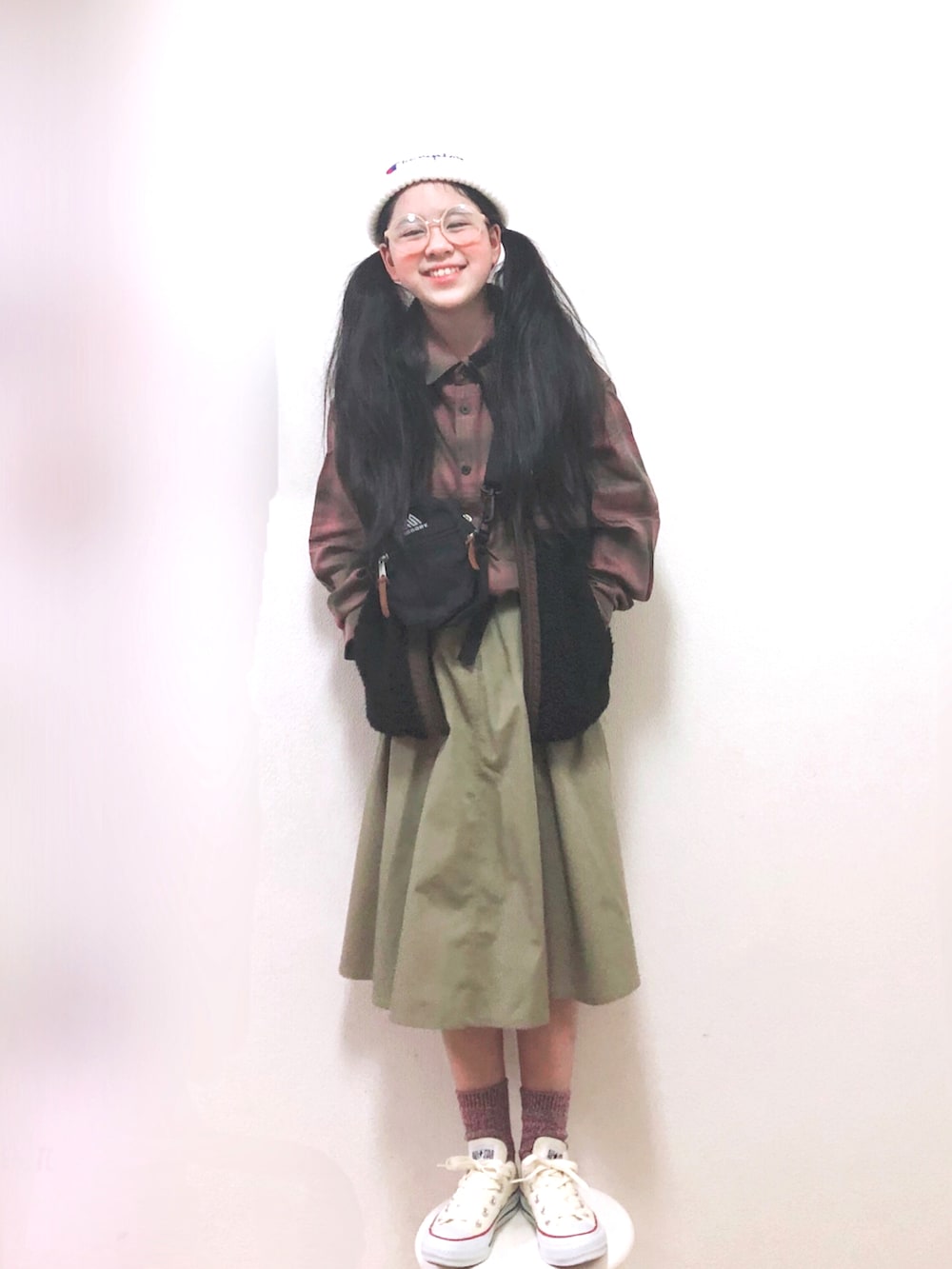 ベージュ系のスカート、ピンク系のシャツ/ブラウス、ブラック系のベストを着用したキッズの冬コーディネートの2枚目の写真