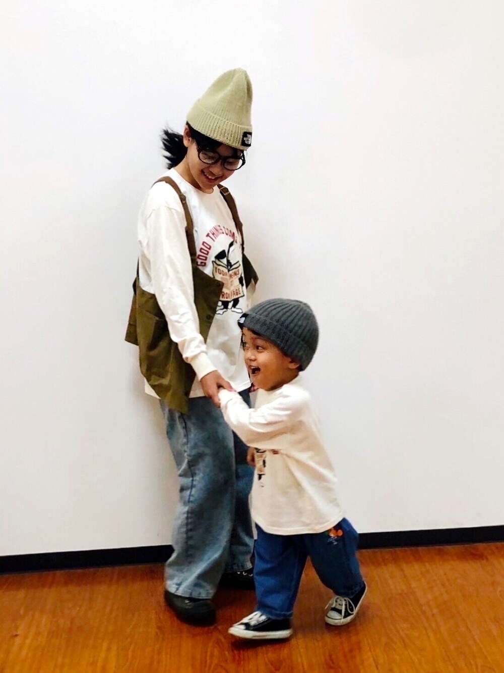 ベージュ系のベスト、ホワイト系のTシャツ/カットソー、ブルー系のデニムパンツを着用したキッズの秋コーディネートの4枚目の写真