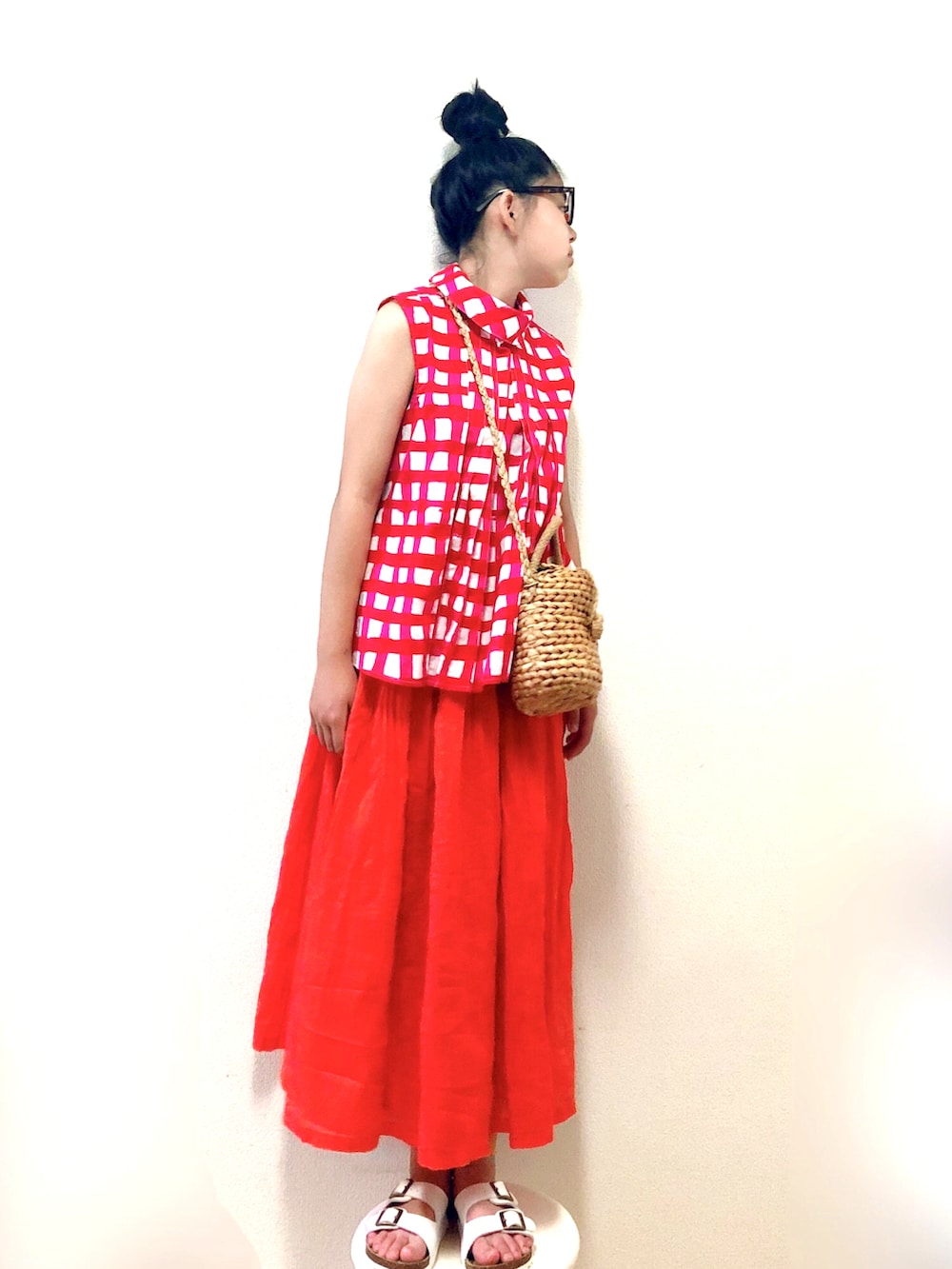 オレンジ系のスカート、ピンク系のシャツ/ブラウス、ベージュ系のかごバッグを着用したキッズの夏コーディネートの2枚目の写真