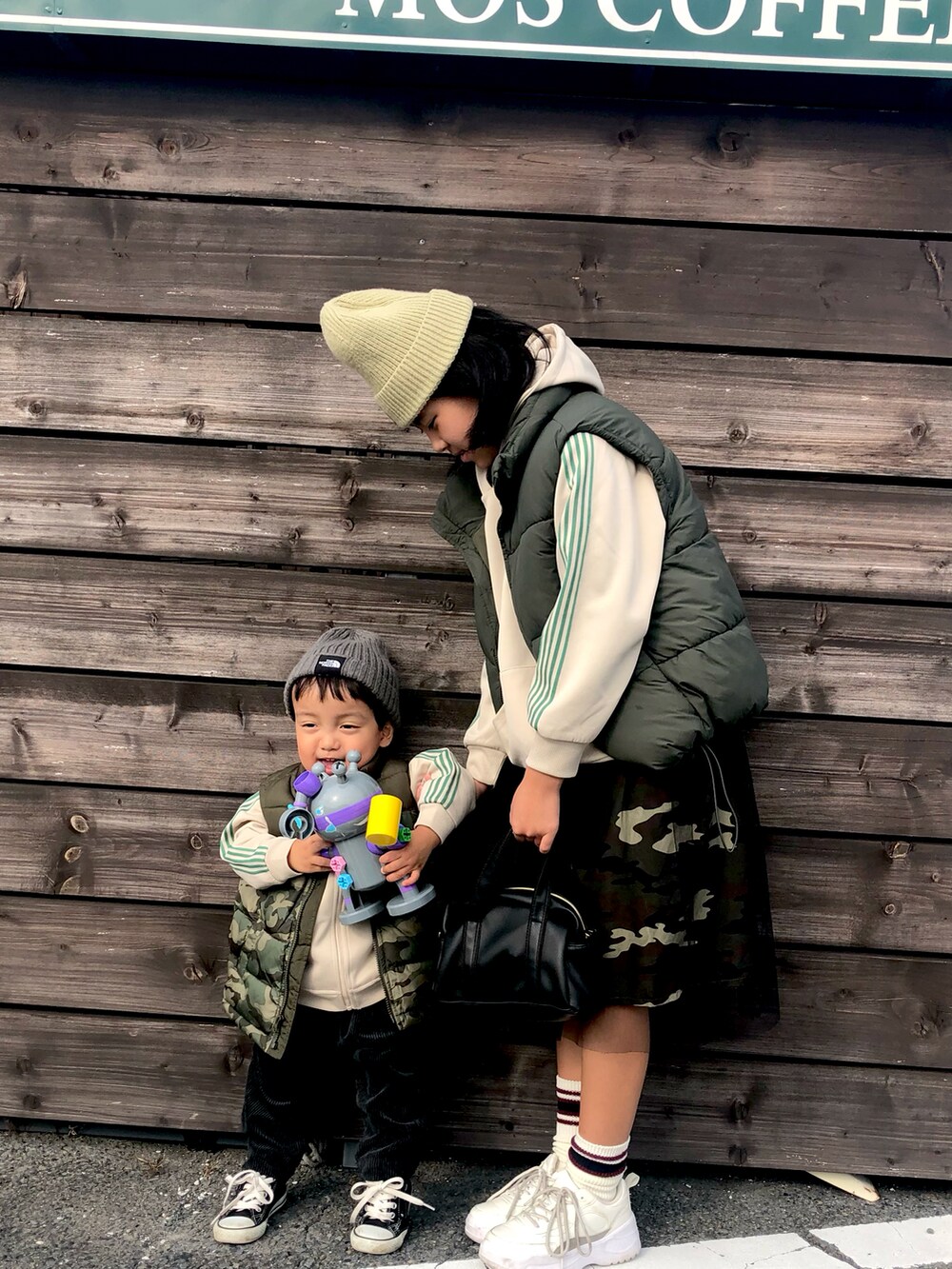 グリーン系のスカート、ホワイト系のその他アウター、グリーン系のダウンベストを着用したキッズの冬コーディネートの2枚目の写真