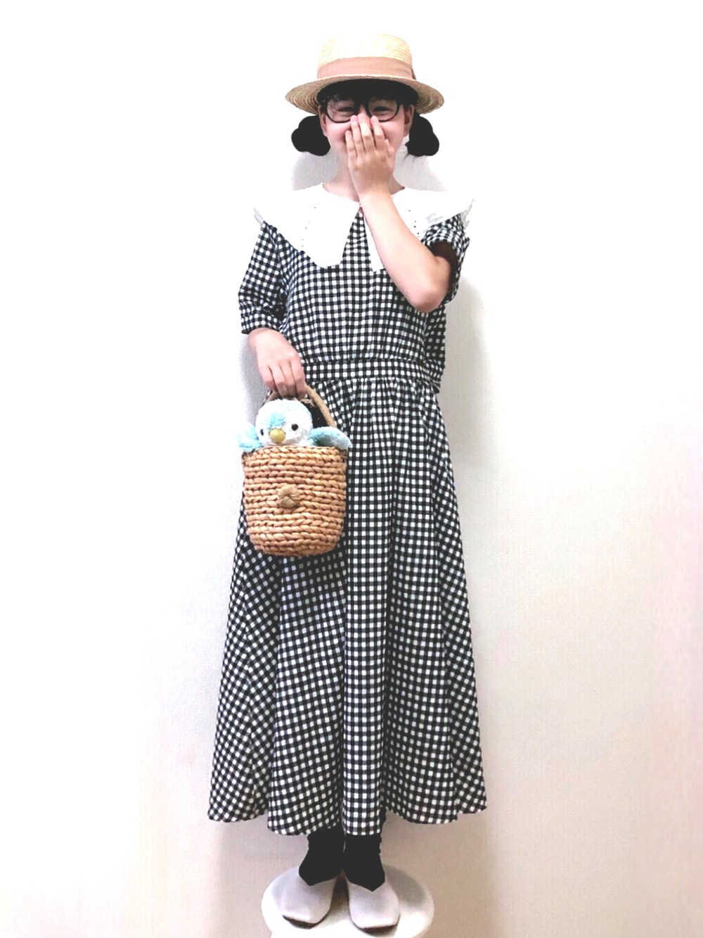 ブラック系のワンピース、ベージュ系のかごバッグ、ホワイト系のパンプスを着用したキッズの春コーディネートの2枚目の写真