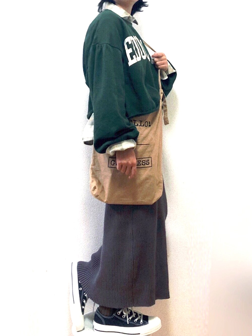 グレー系のスカート、グリーン系のスウェット、ベージュ系のシャツ/ブラウスを着用したキッズの秋コーディネートの2枚目の写真