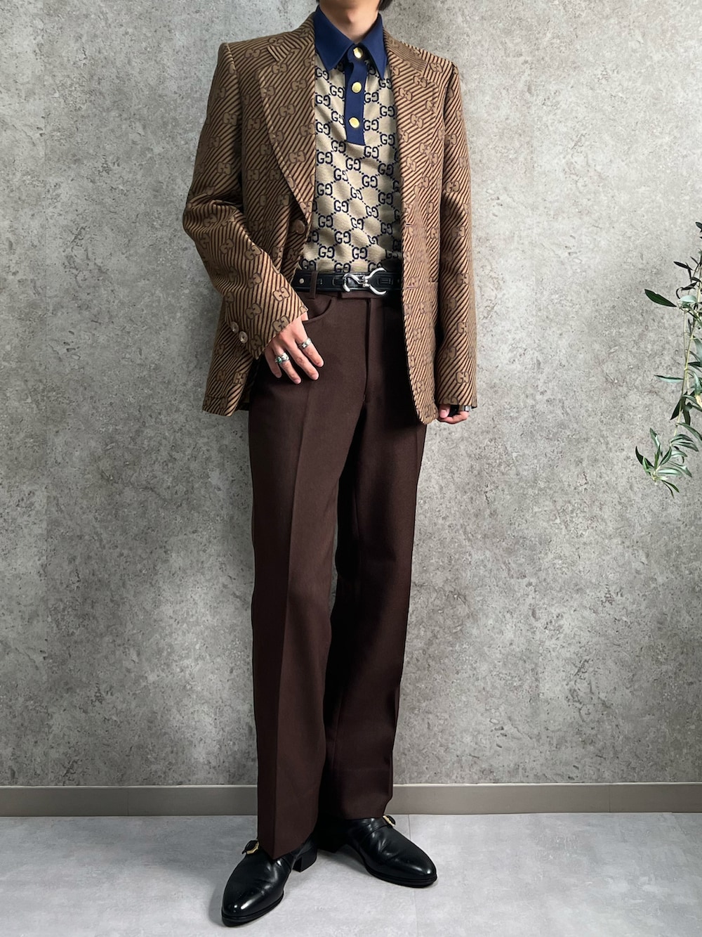 ブラウン系のテーラードジャケット、ブラウン系のポロシャツ、ブラウン系のショルダーバッグを着用したメンズの秋コーディネートの2枚目の写真