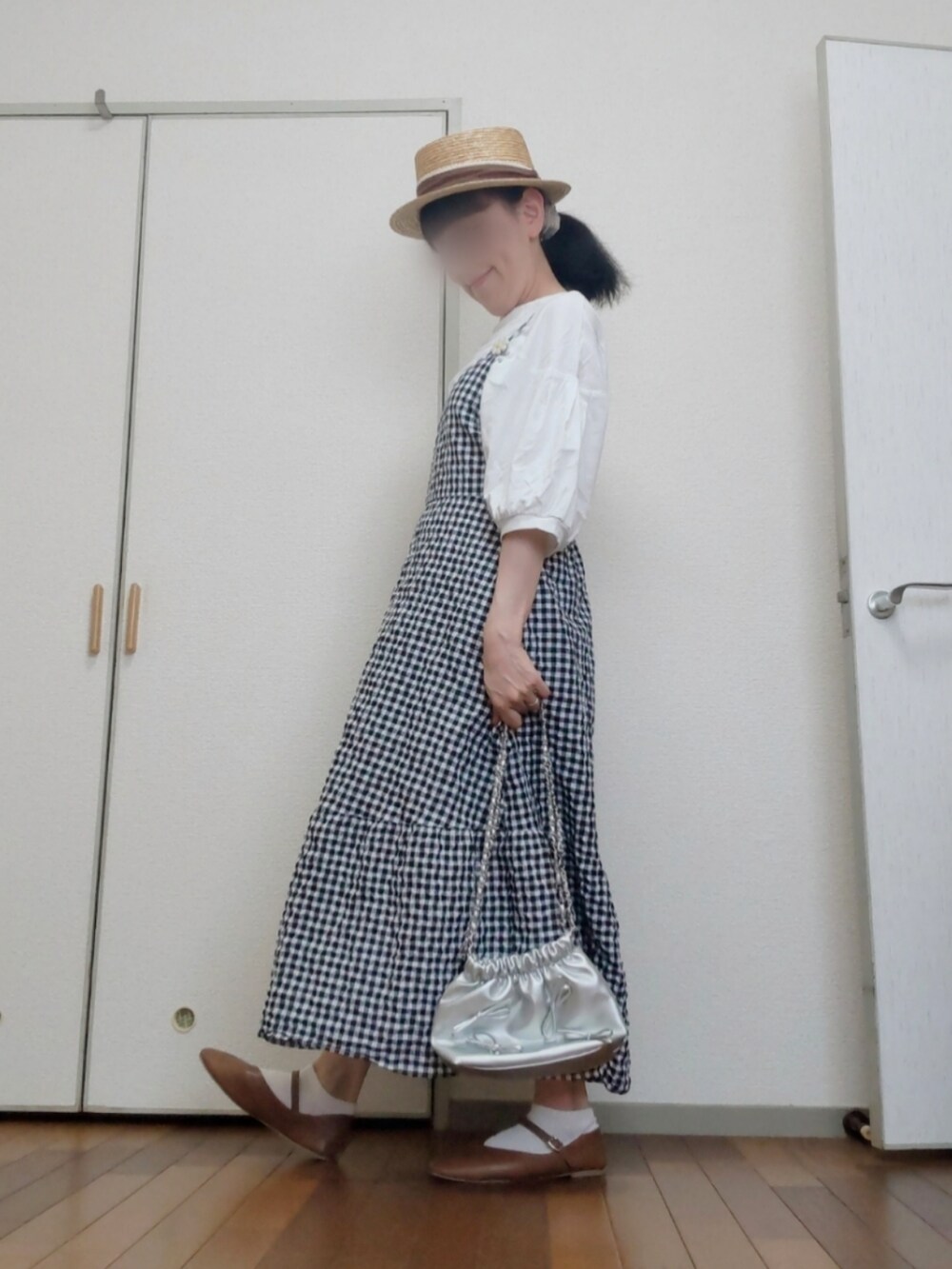 ブラック系のワンピース、ホワイト系のTシャツ/カットソー、シルバー系のショルダーバッグを着用したレディースの夏コーディネートの2枚目の写真