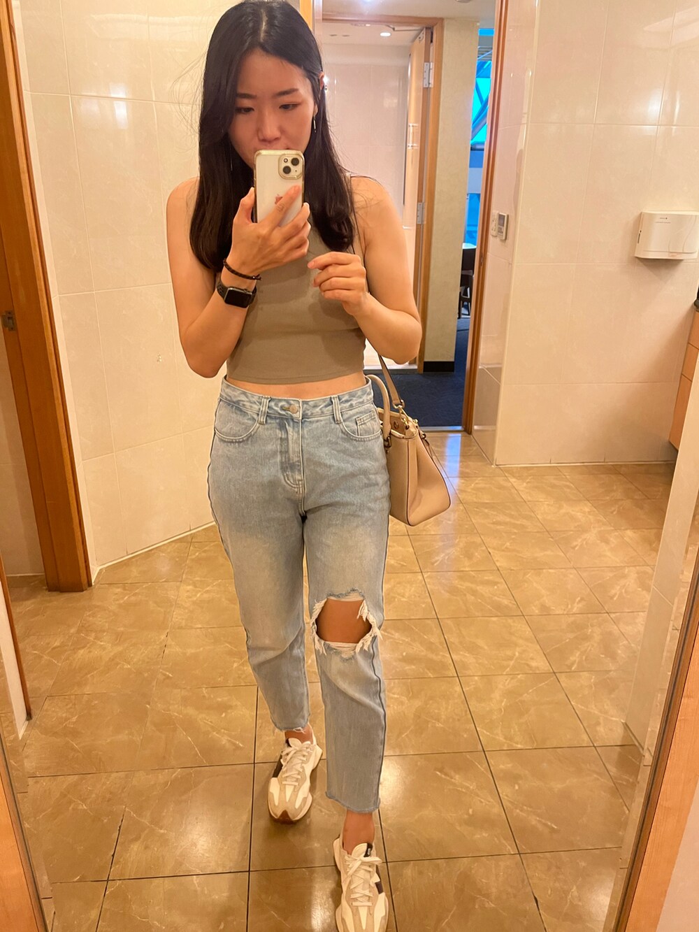 その他のチューブトップ、ブルー系のデニムパンツ、ベージュ系のスニーカーを着用したレディースの秋コーディネートの4枚目の写真