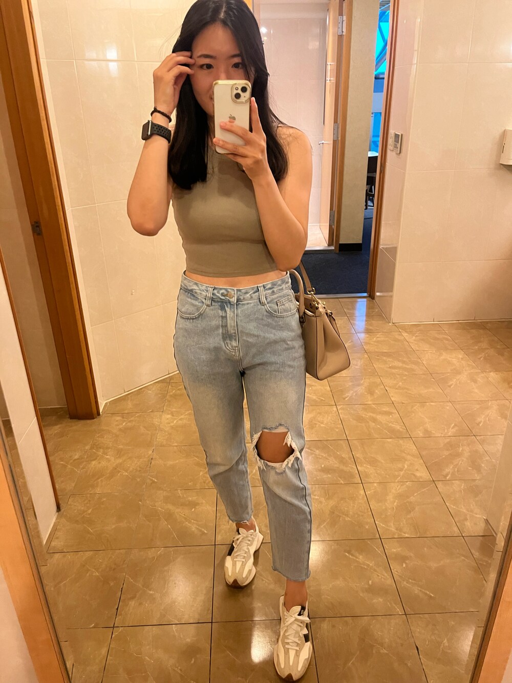 その他のチューブトップ、ブルー系のデニムパンツ、ベージュ系のスニーカーを着用したレディースの秋コーディネートの5枚目の写真