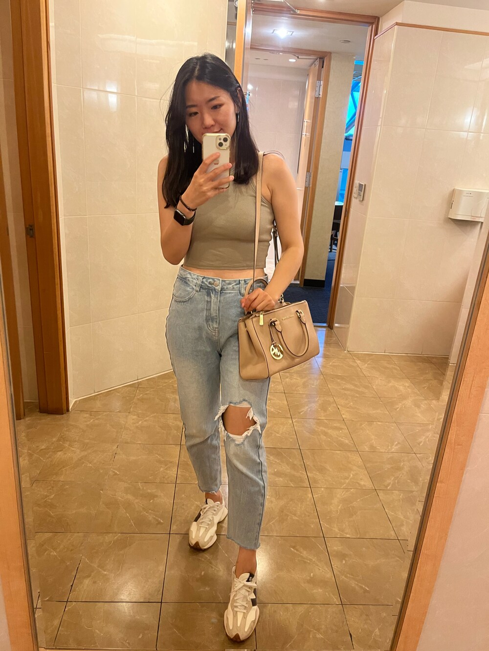 その他のチューブトップ、ブルー系のデニムパンツ、ベージュ系のスニーカーを着用したレディースの秋コーディネートの2枚目の写真