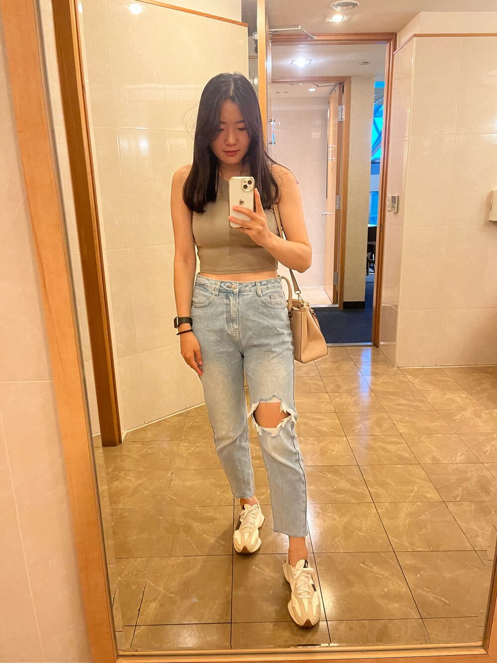 その他のチューブトップ、ブルー系のデニムパンツ、ベージュ系のスニーカーを着用したレディースの秋コーディネートの3枚目の写真