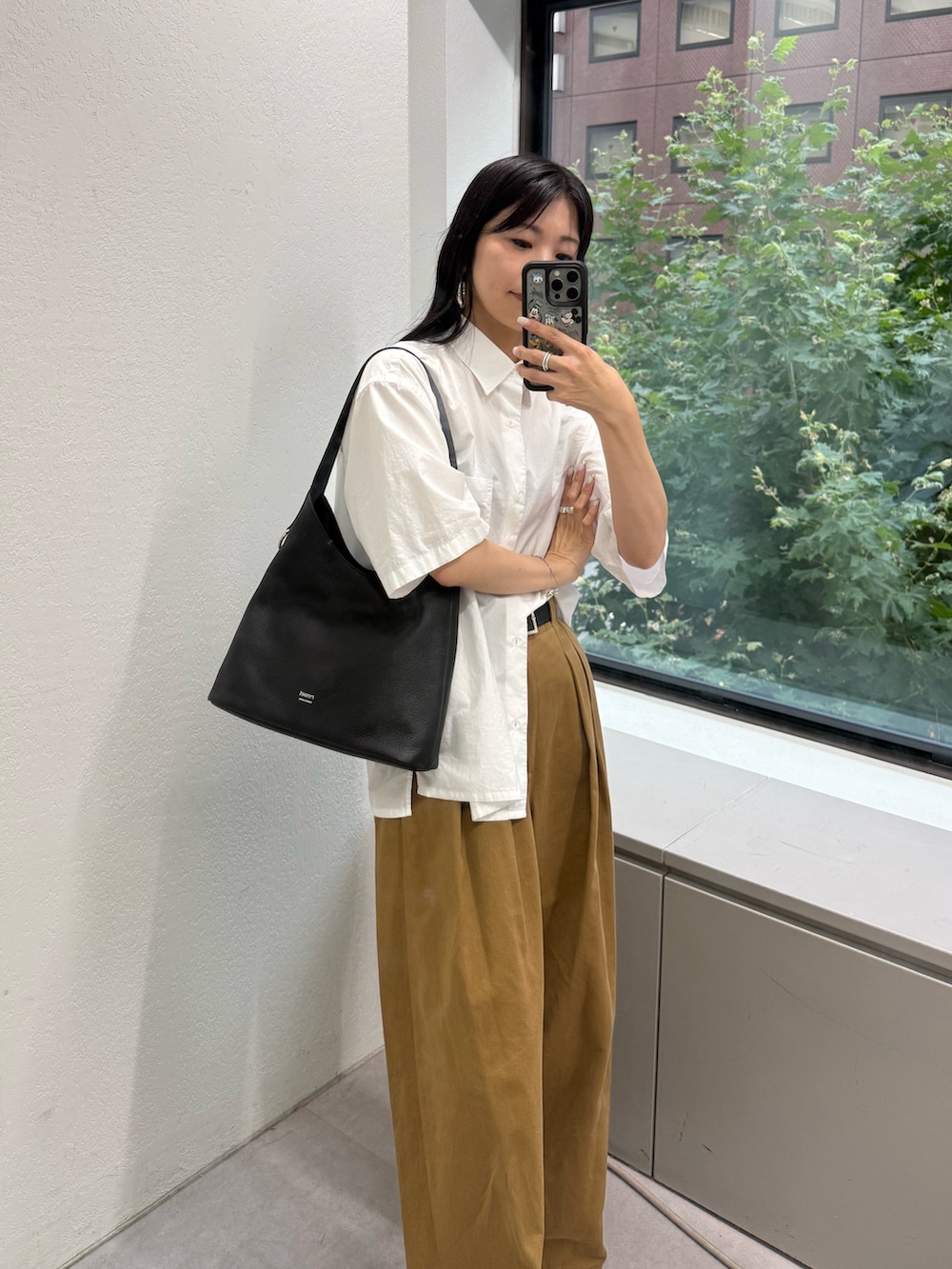 ブラック系のショルダーバッグを着用したレディースの夏コーディネートの2枚目の写真