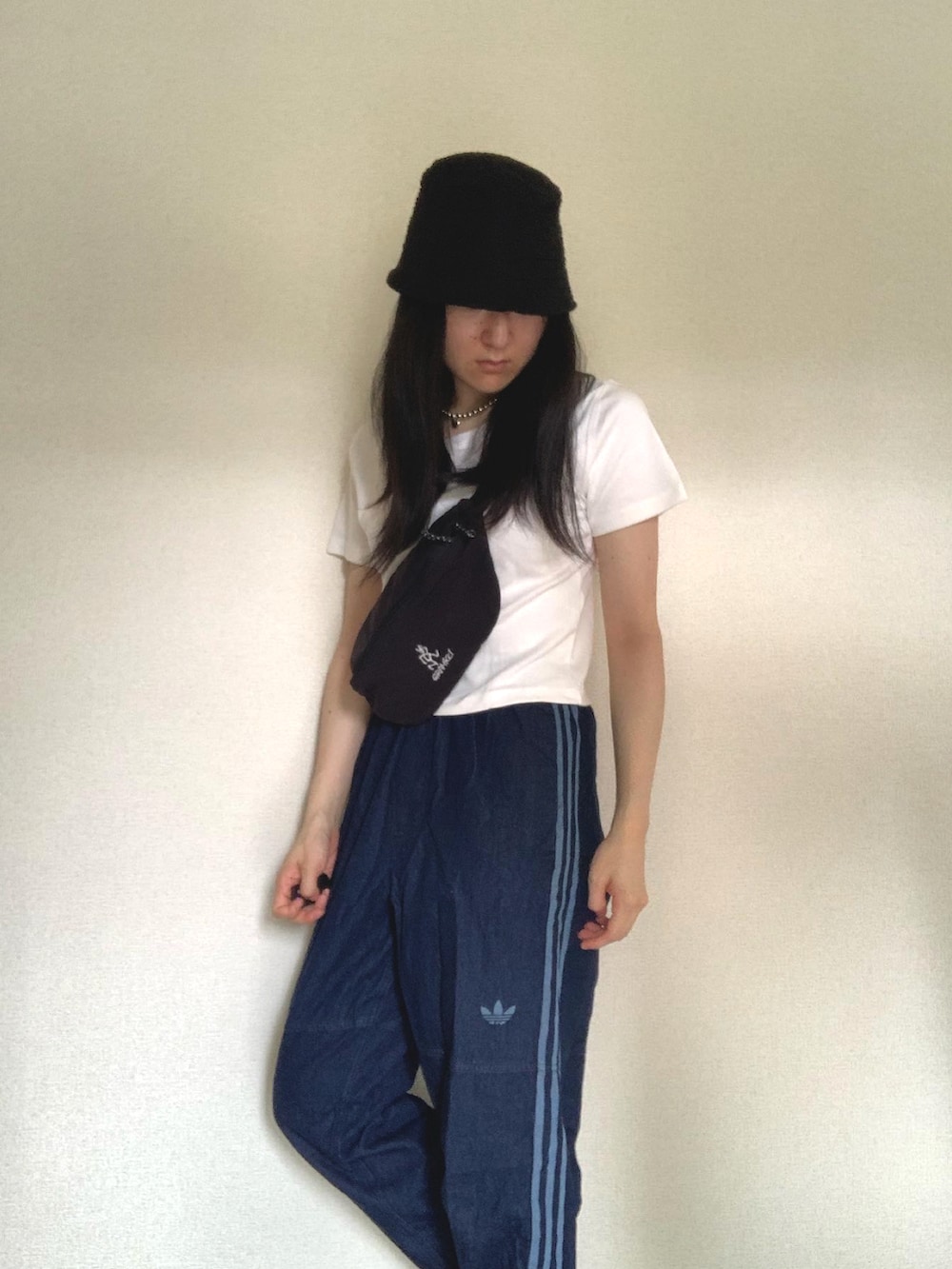 ブルー系のデニムパンツ、ブラック系のボディバッグ/ウエストポーチ、ホワイト系のTシャツ/カットソーを着用したレディースの夏コーディネートの2枚目の写真