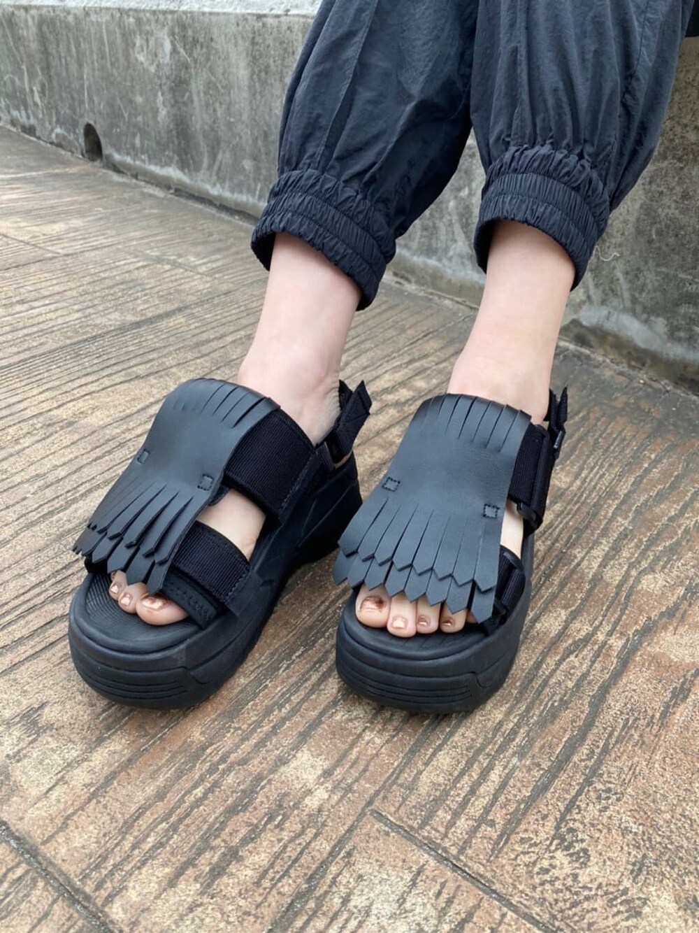 ブラック系のその他パンツ、ホワイト系のサンダル、ブラック系のニット/セーターを着用したレディースの冬コーディネートの8枚目の写真