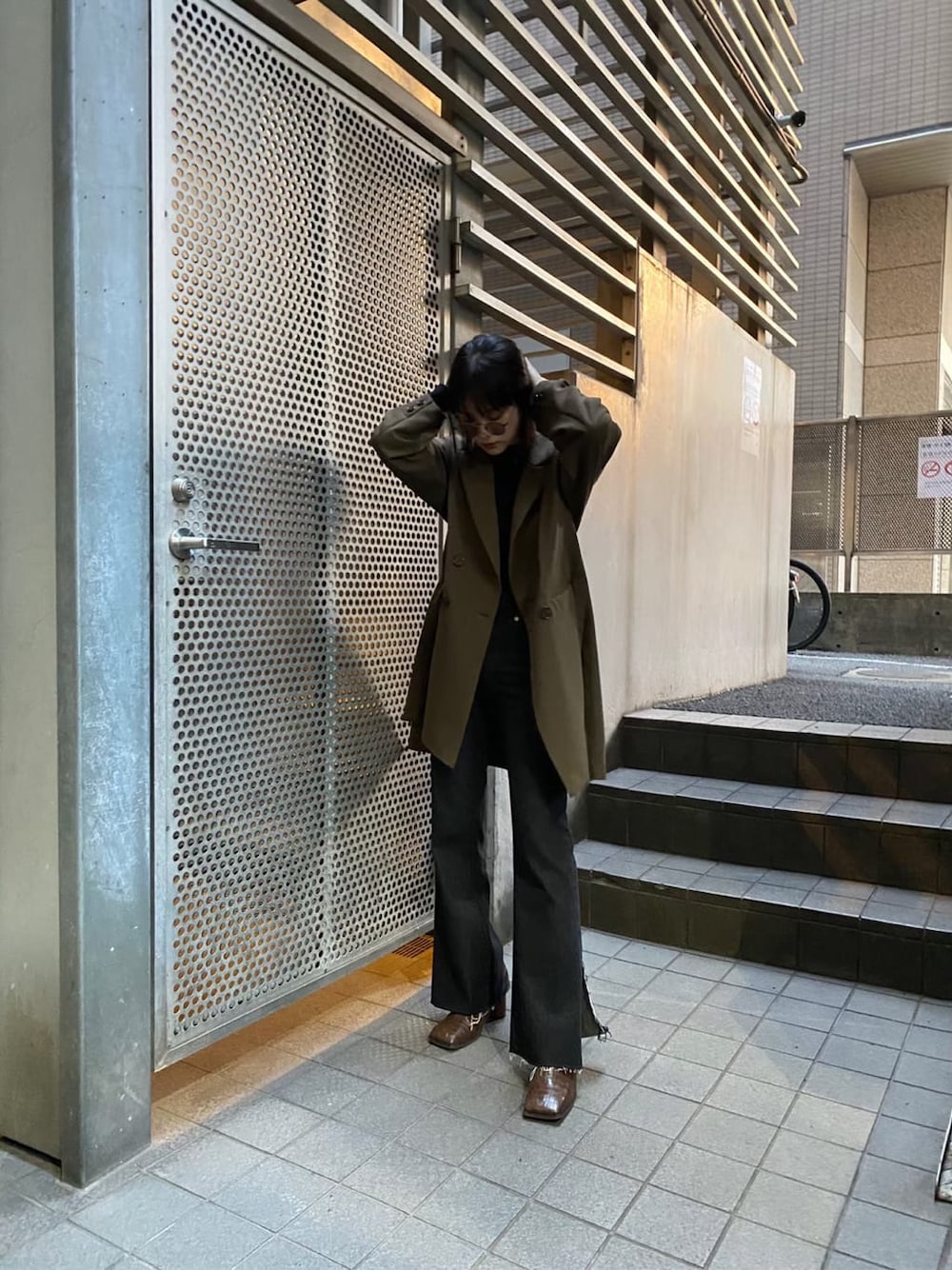 ベージュ系のテーラードジャケット、ブラウン系のパンプス、ブラック系のデニムパンツを着用したレディースの秋コーディネートの5枚目の写真