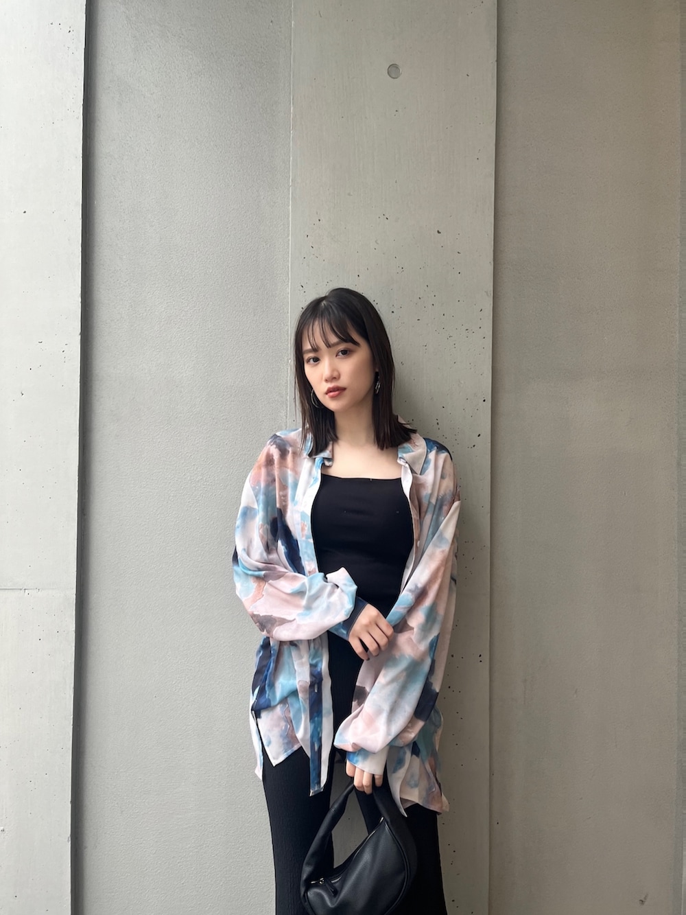 ブラック系のハンドバッグ、ブラック系のサンダル、ブルー系のシャツ/ブラウスを着用したレディースの冬コーディネートの3枚目の写真