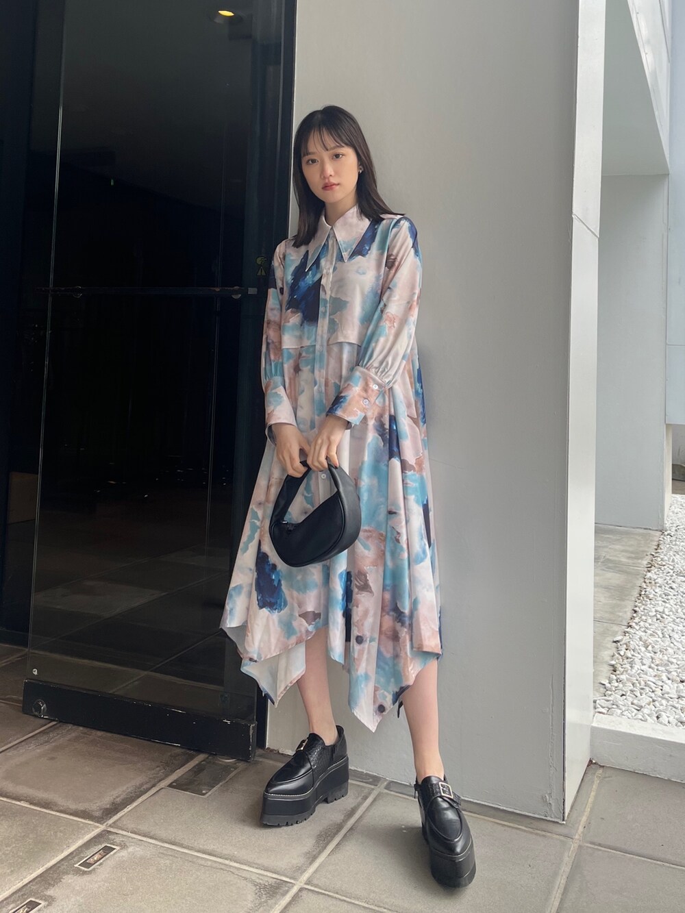 ブルー系のワンピース、ブラック系のハンドバッグ、ブラック系のローファーを着用したレディースの冬コーディネートの3枚目の写真