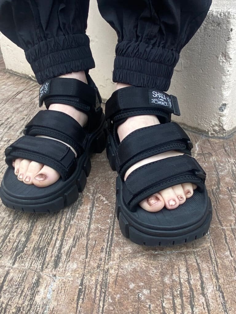 ブラック系のその他パンツ、ホワイト系のサンダル、ブラック系のニット/セーターを着用したレディースの冬コーディネートの6枚目の写真