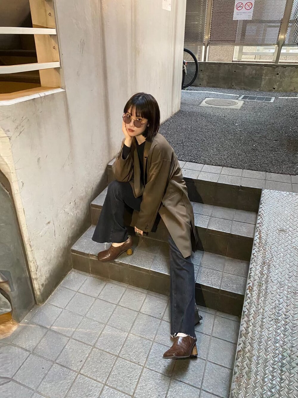 ベージュ系のテーラードジャケット、ブラウン系のパンプス、ブラック系のデニムパンツを着用したレディースの秋コーディネートの4枚目の写真