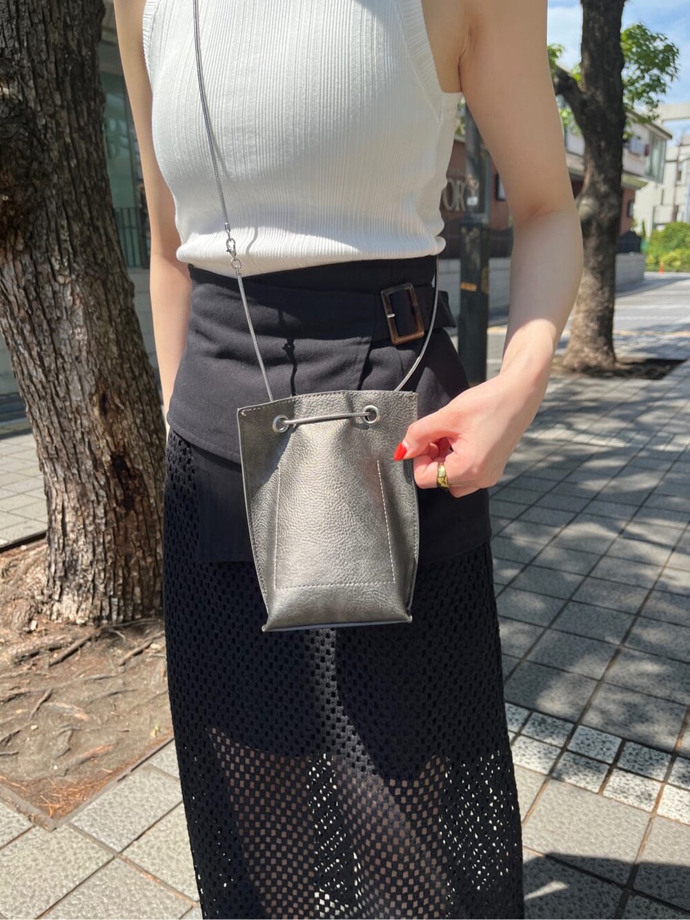 ホワイト系のサンダル、ブラック系のスカート、ホワイト系のタンクトップを着用したレディースの夏コーディネートの8枚目の写真