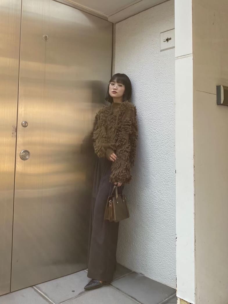 ブラック系のスラックス、ブラック系のパンプス、ブラウン系のハンドバッグを着用したレディースの秋コーディネートの6枚目の写真