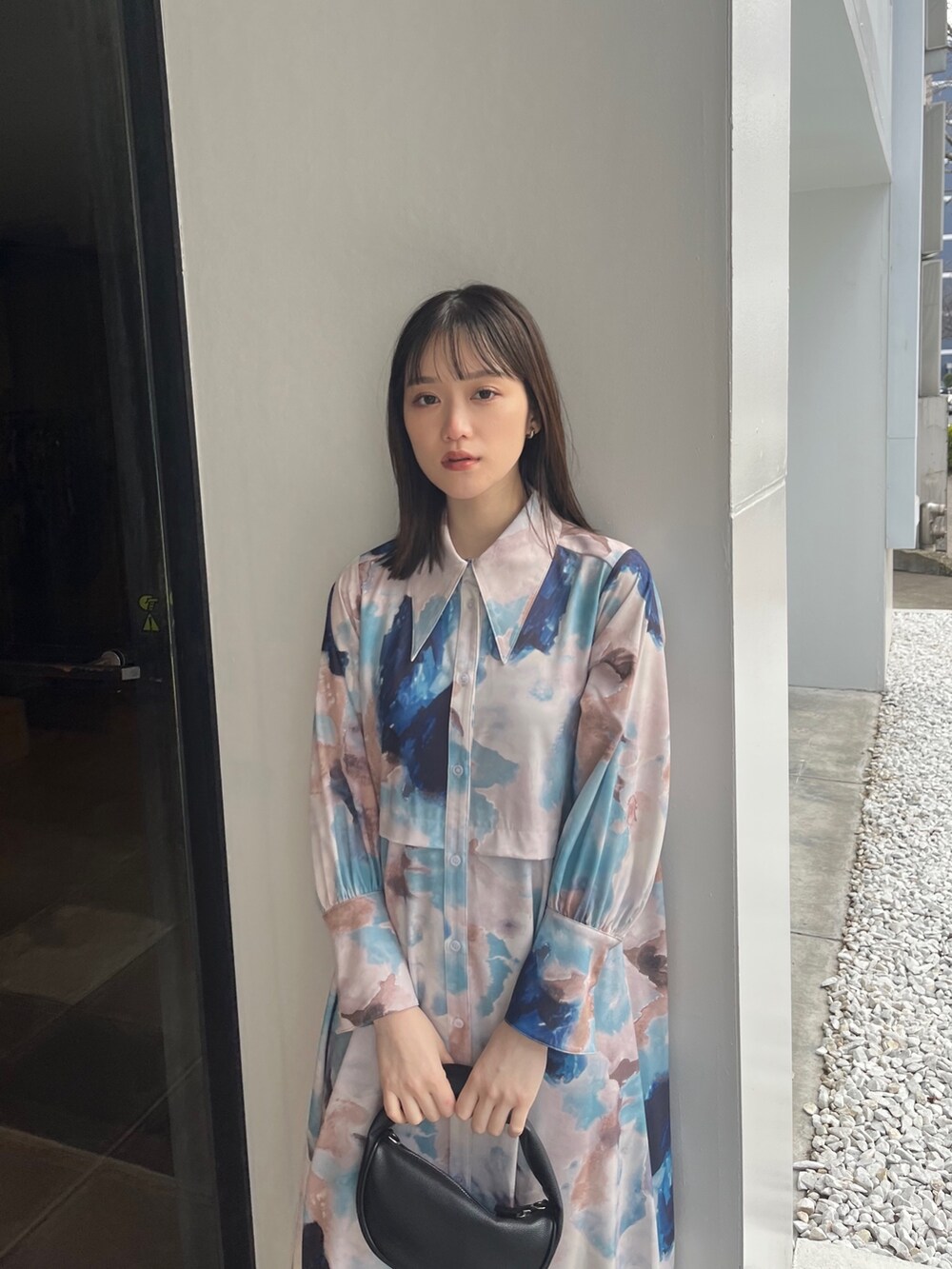 ブルー系のワンピース、ブラック系のハンドバッグ、ブラック系のローファーを着用したレディースの冬コーディネートの2枚目の写真