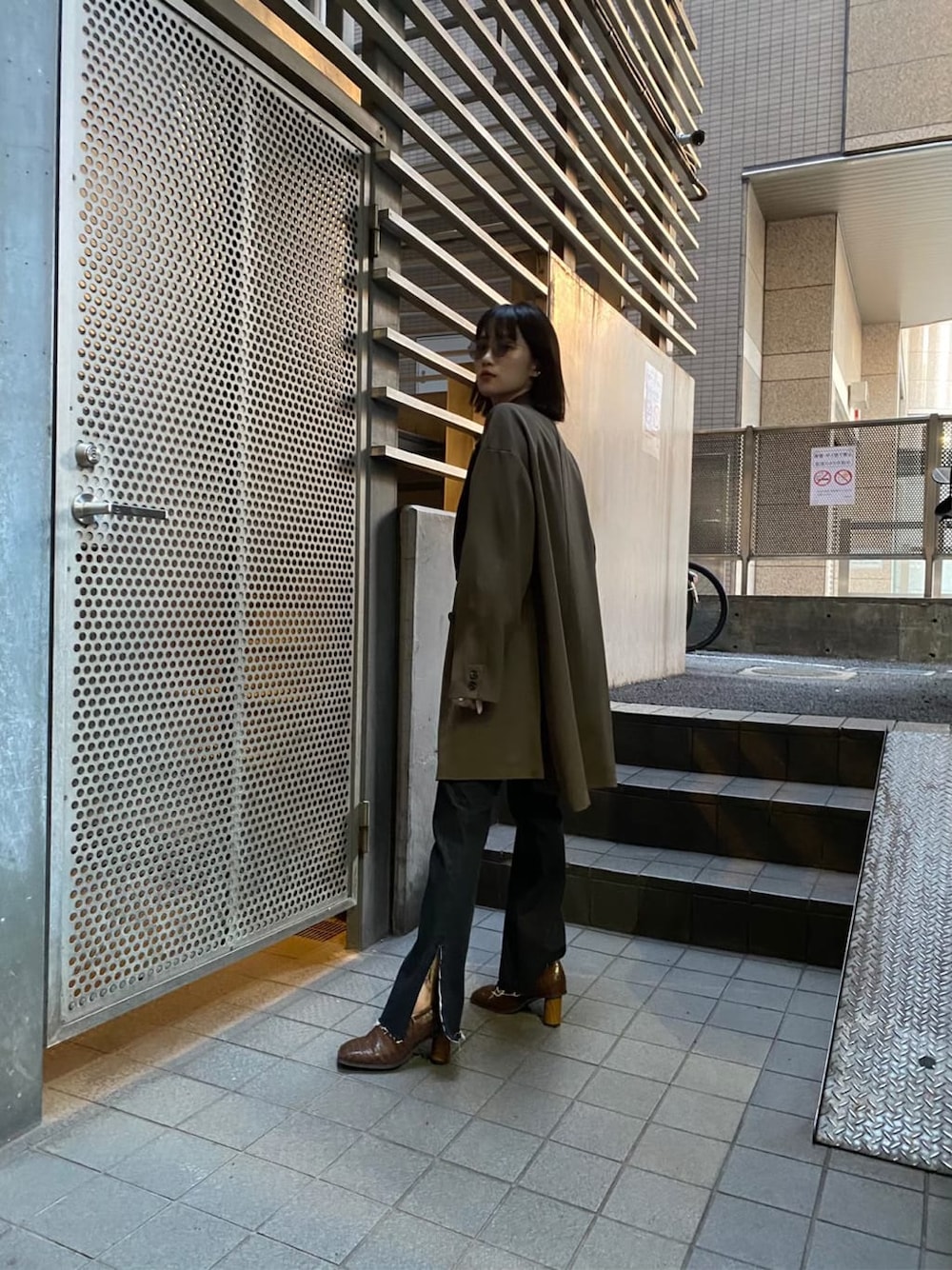 ベージュ系のテーラードジャケット、ブラウン系のパンプス、ブラック系のデニムパンツを着用したレディースの秋コーディネートの6枚目の写真