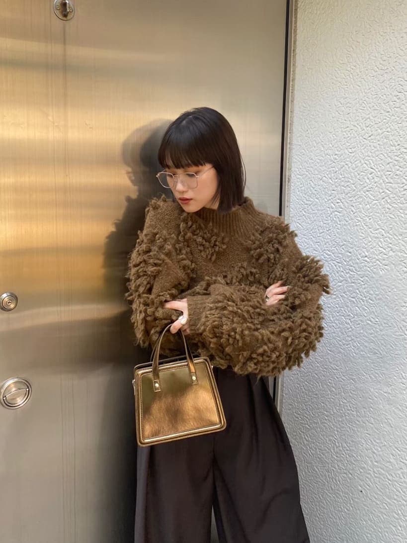 ブラック系のスラックス、ブラック系のパンプス、ブラウン系のハンドバッグを着用したレディースの秋コーディネートの4枚目の写真