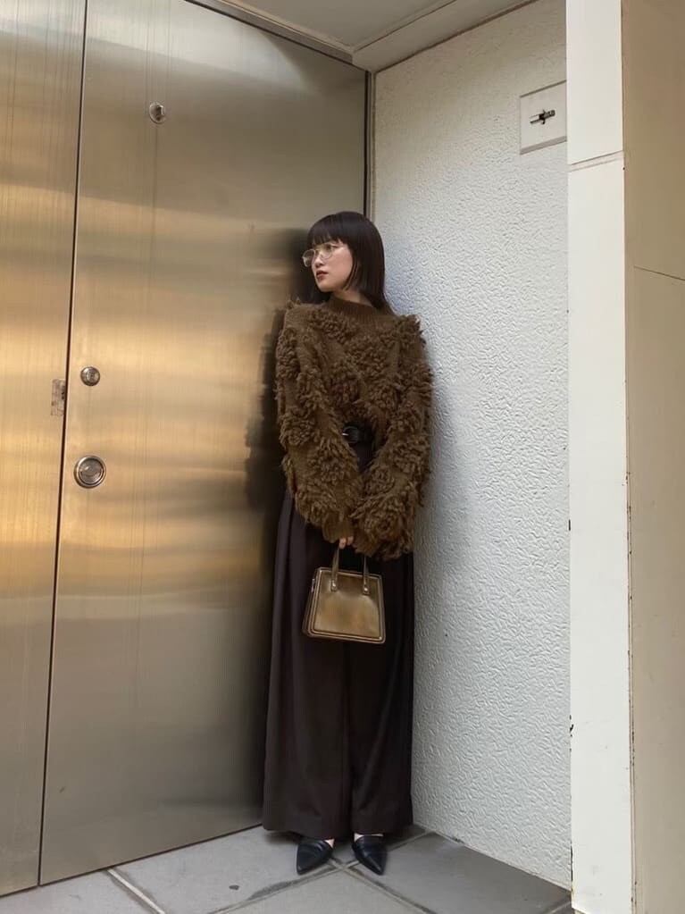 ブラック系のスラックス、ブラック系のパンプス、ブラウン系のハンドバッグを着用したレディースの秋コーディネートの5枚目の写真